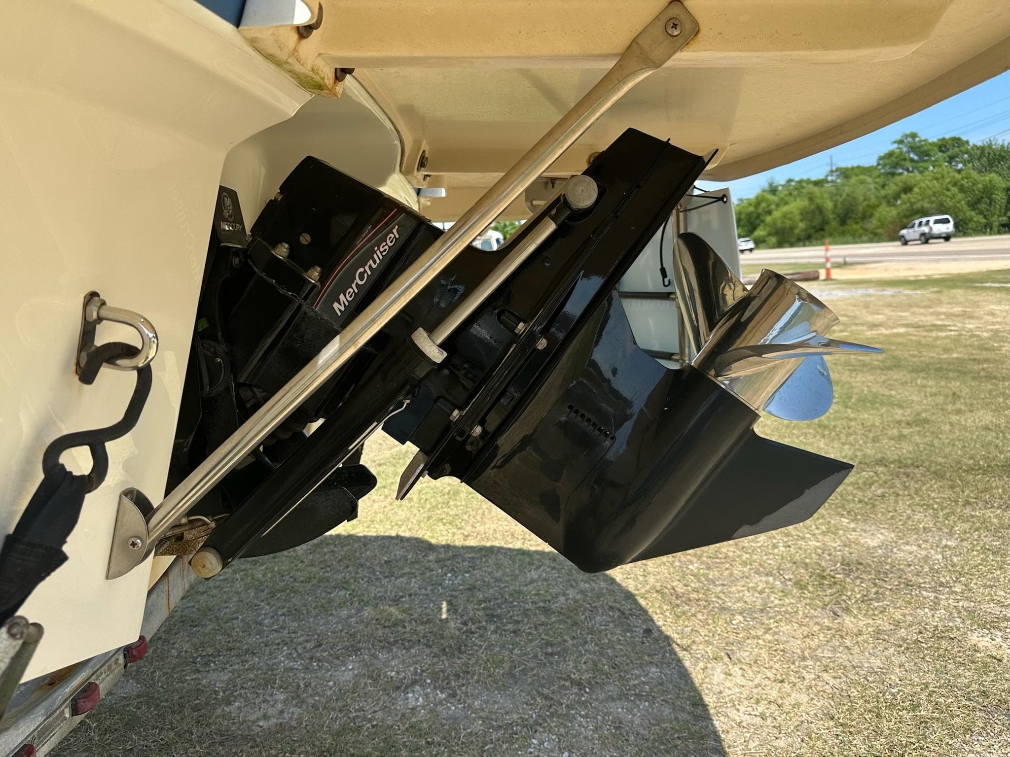 2011 Bayliner 184 SF boat with MerCruiser outboard motor and propeller, parked on grass.