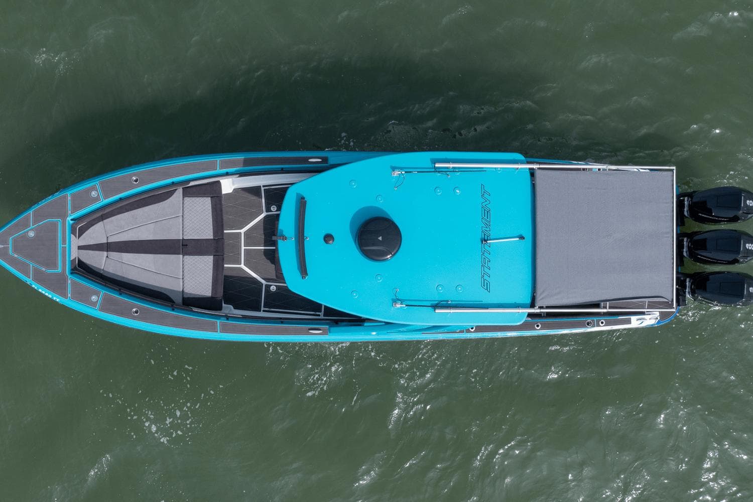 Top view of 2024 Statement 38 Open boat on water, featuring sleek design and triple engines.