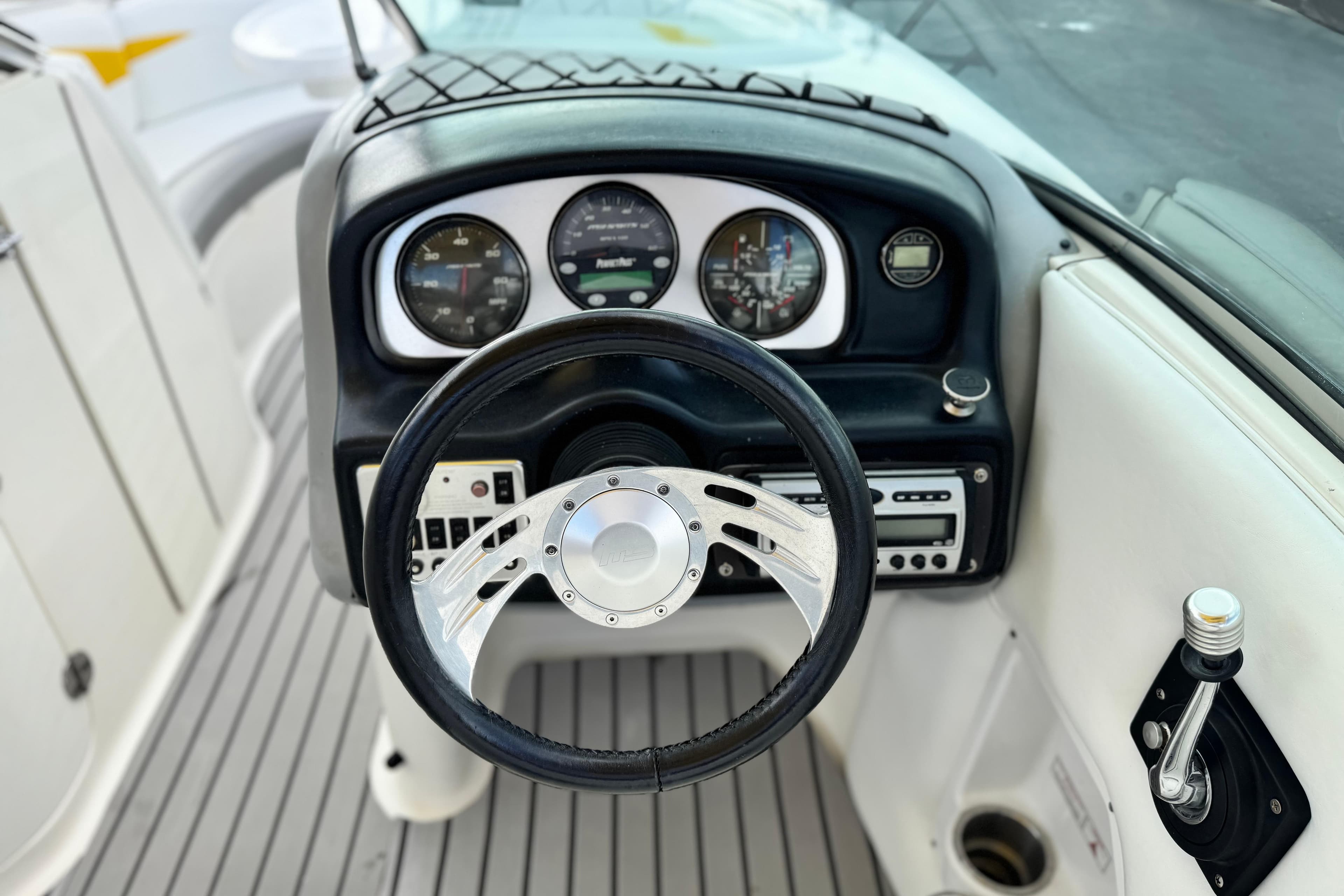 Steering console of 2005 MB 240 V Sportdeck boat with gauges and controls.