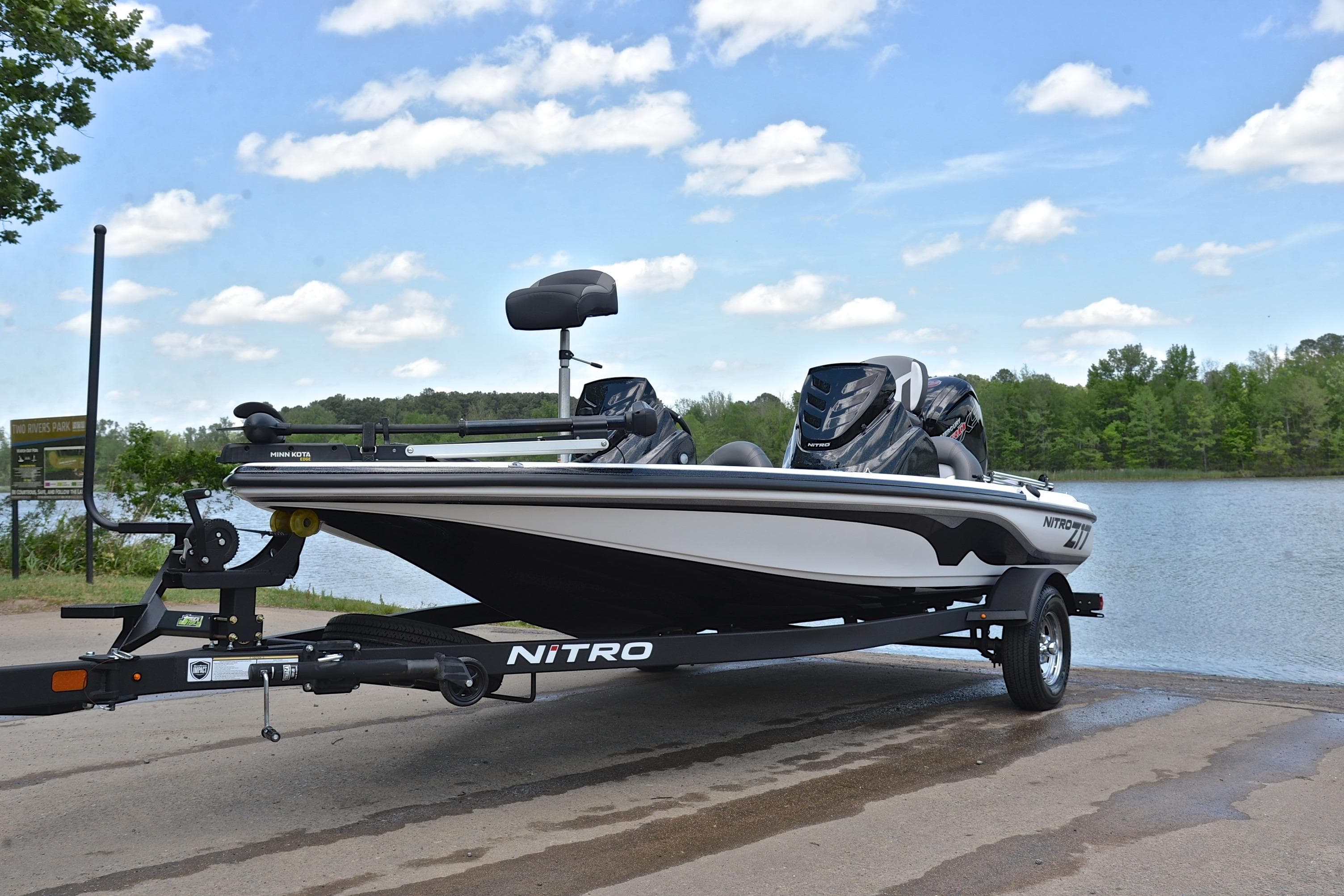 2025 Nitro Z17 boat on trailer by a scenic lake under a blue sky.
