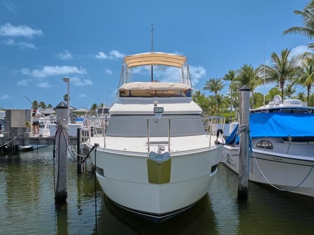 2015 Carver C34 Command Bridge yacht docked at marina under clear blue sky.