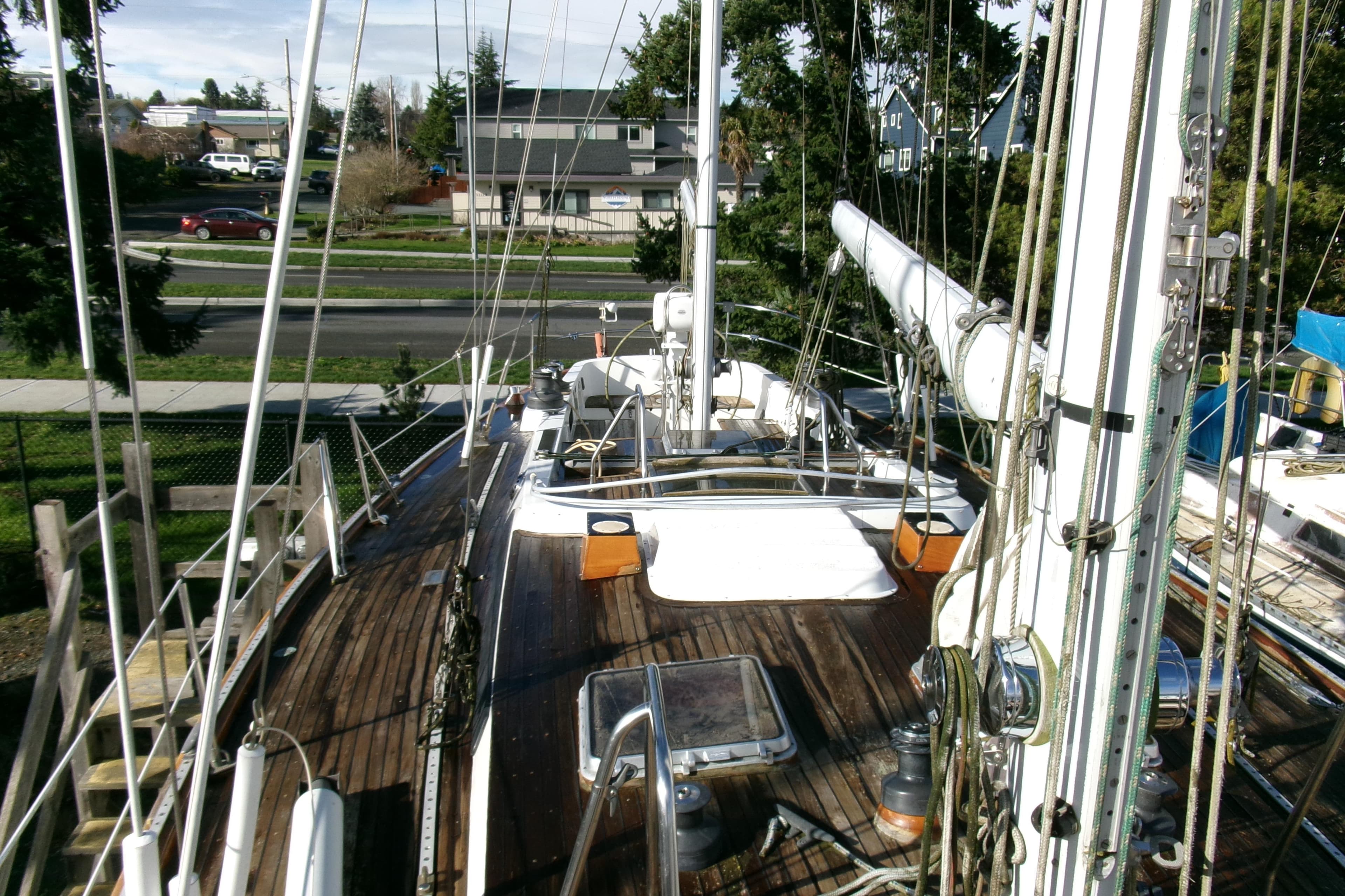 1980 Ketch 51 sailboat deck with rigging and wooden finish, docked near residential area.
