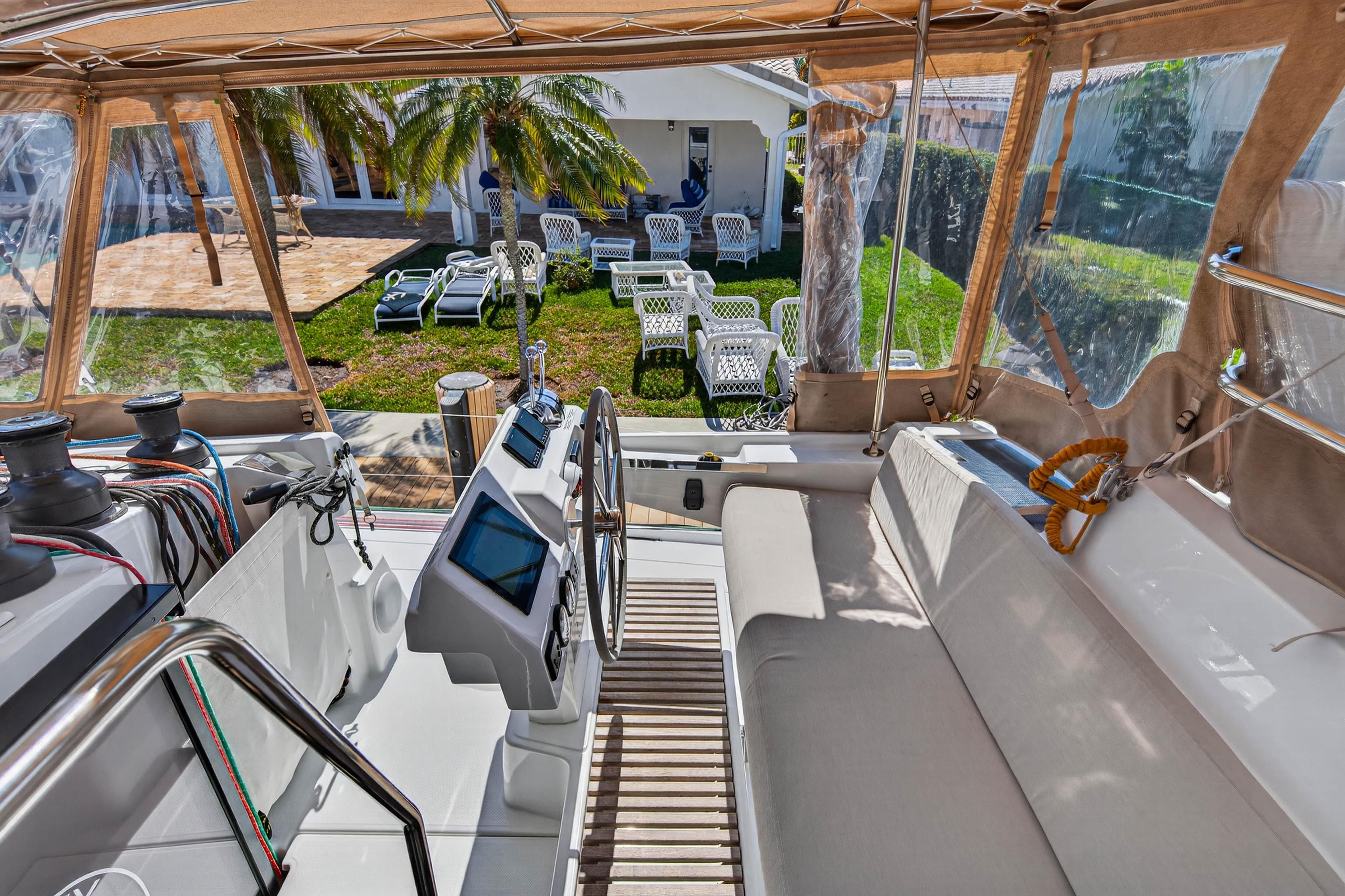 2022 Fountaine Pajot Tanna 47 yacht cockpit with helm, overlooking garden and patio.