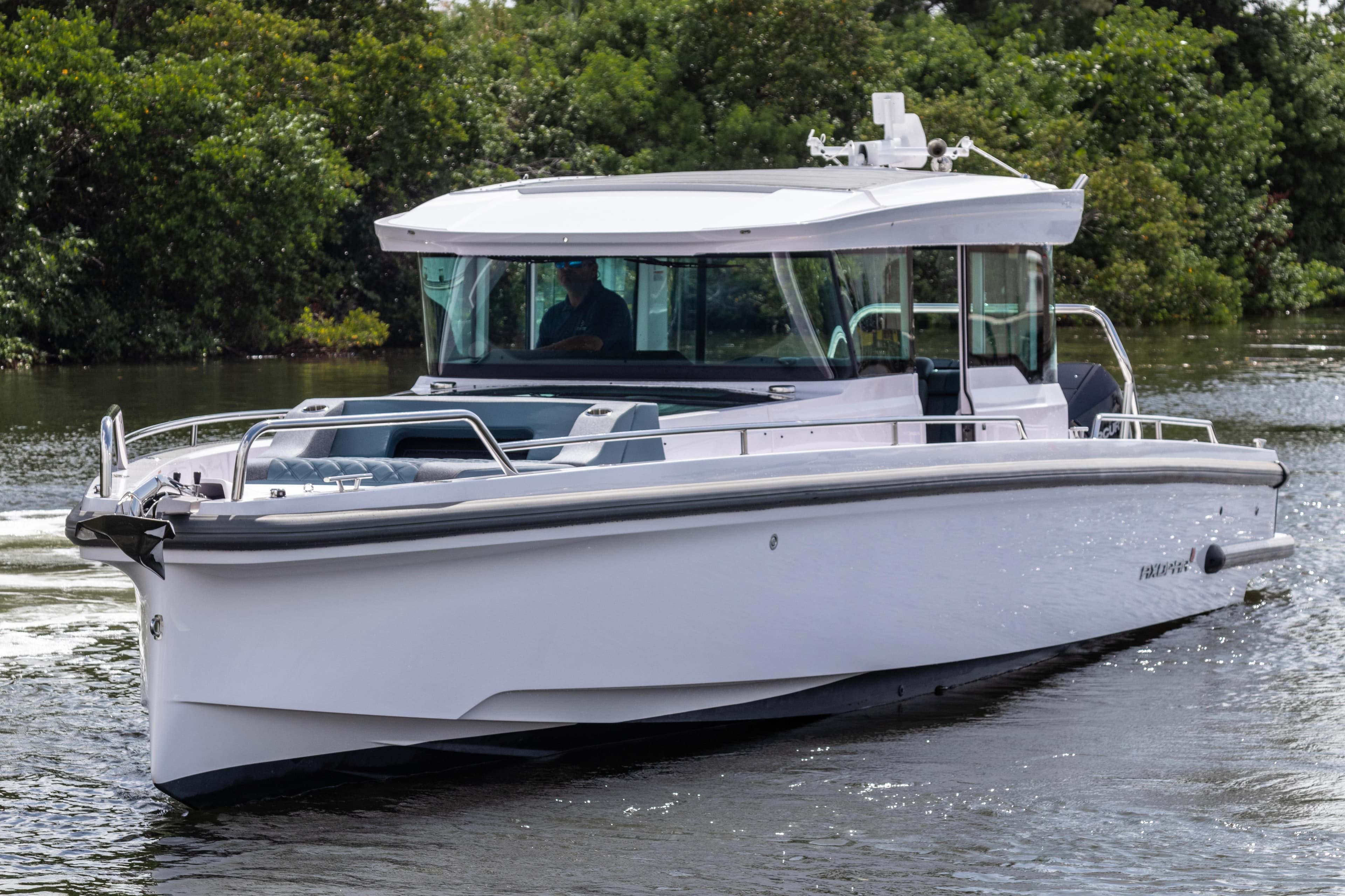 2024 Axopar 37XC CROSS CABIN boat cruising on a calm waterway.