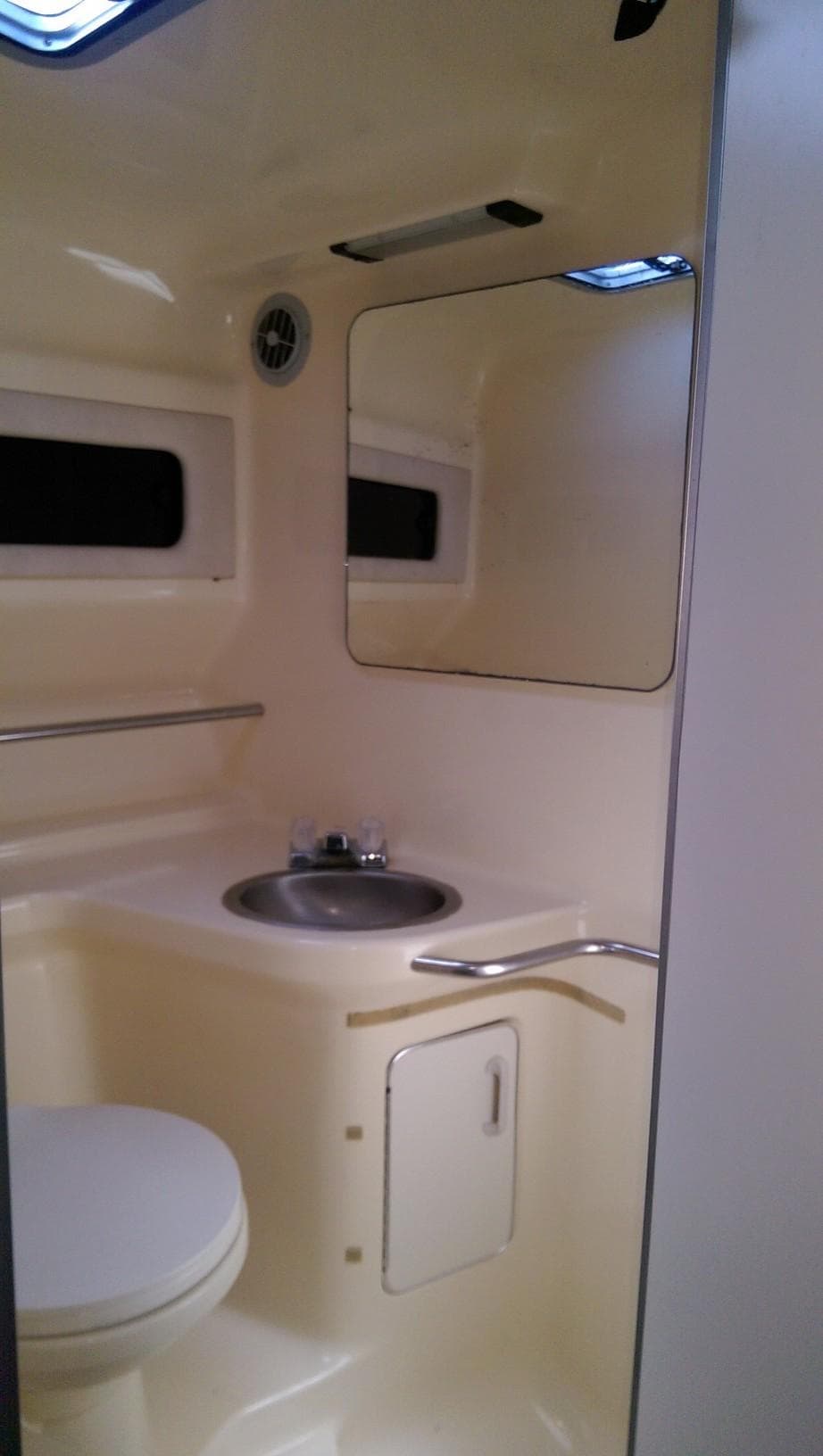 1993 Sea Ray 330 Express Cruiser bathroom with sink, mirror, and toilet.