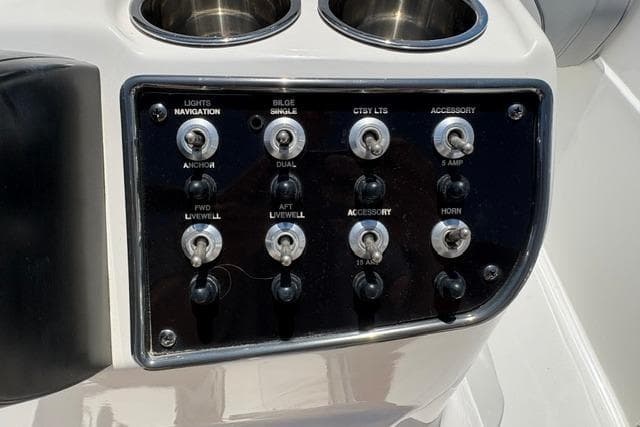 Control panel of a 2021 NauticStar 211 Hybrid boat with various switches.