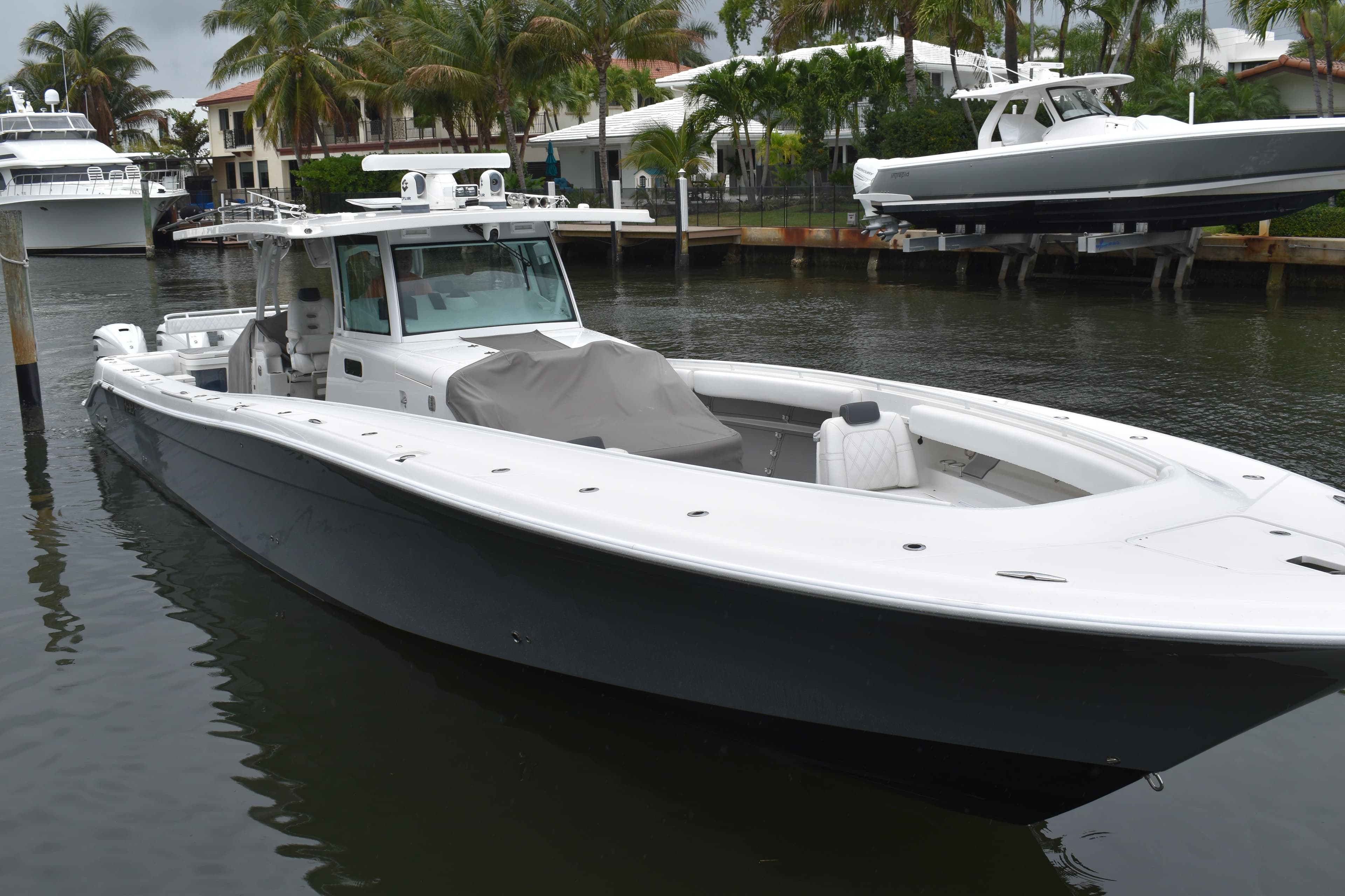 2019 HCB 53 Suenos boat docked in a marina, surrounded by palm trees.