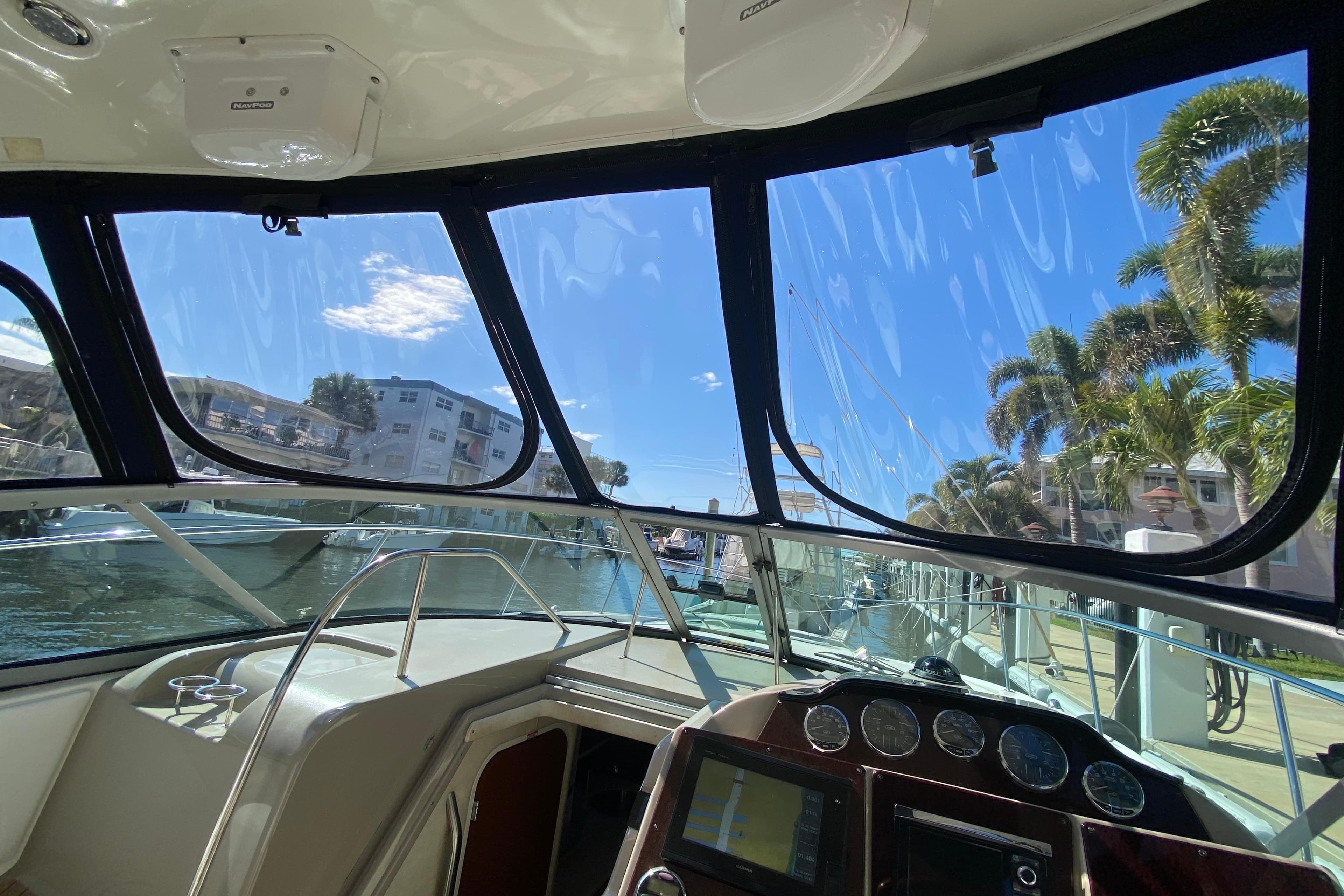 2008 Sea Ray Sundancer 330 cockpit view with marina and palm trees in background.