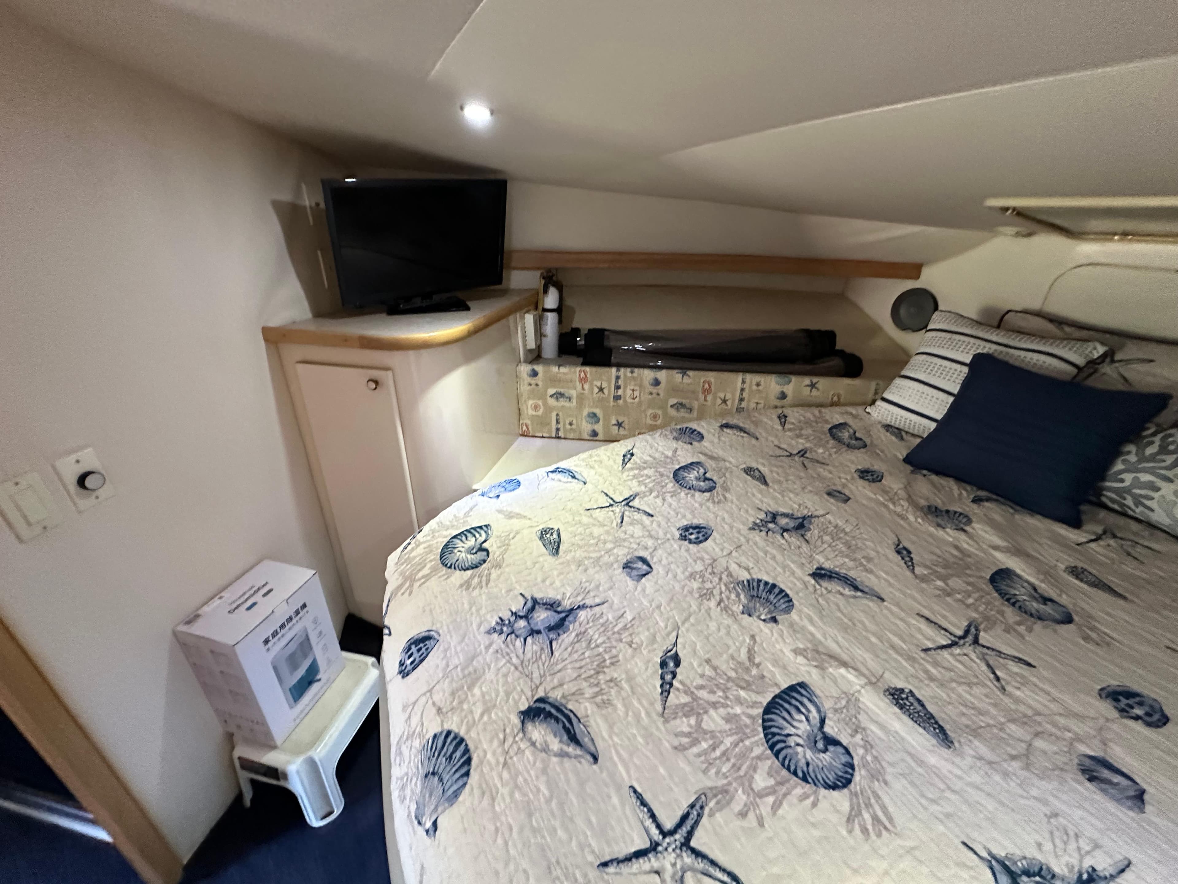 Cozy bedroom in 1996 Carver 38 Santego yacht with nautical-themed bedding.
