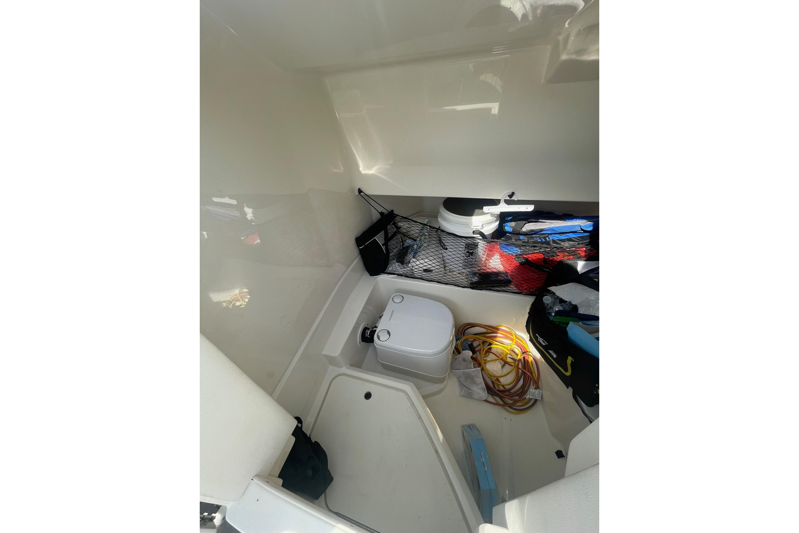Interior storage area of 2019 Sea Ray SDX 250 boat with equipment and supplies.