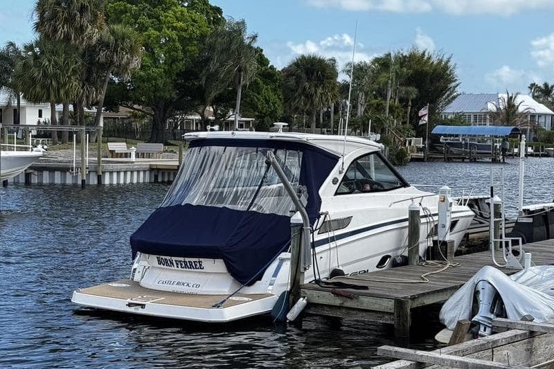 2018 Regal 35 Sport Coupe docked by a scenic waterfront with lush greenery.