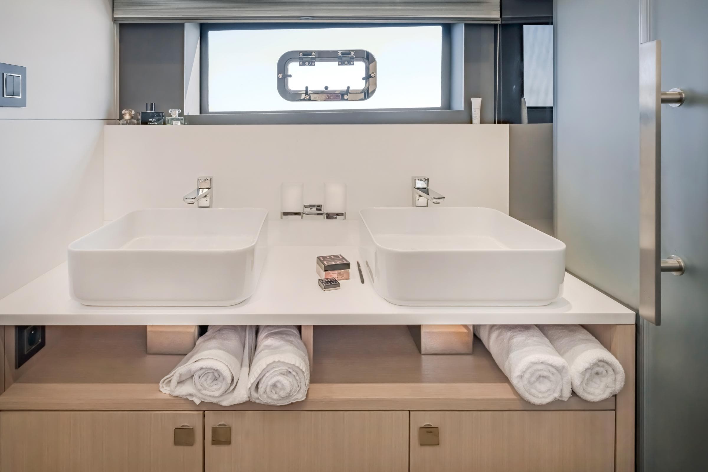 Luxury yacht bathroom with dual sinks, modern design, and rolled towels on Privilege Signature 650, 2025.