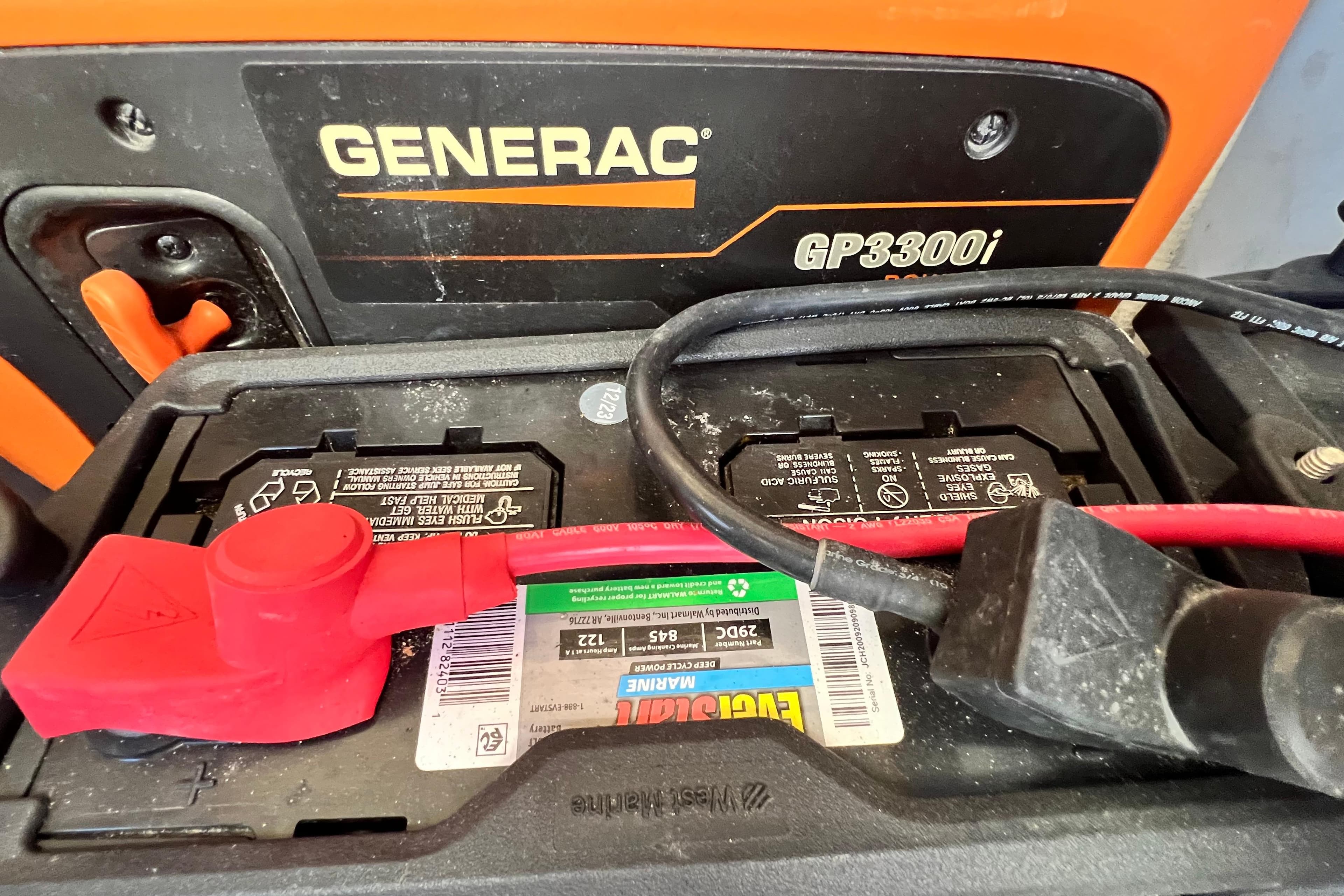 Generac GP3300i generator with battery connections, featuring red and black cables.