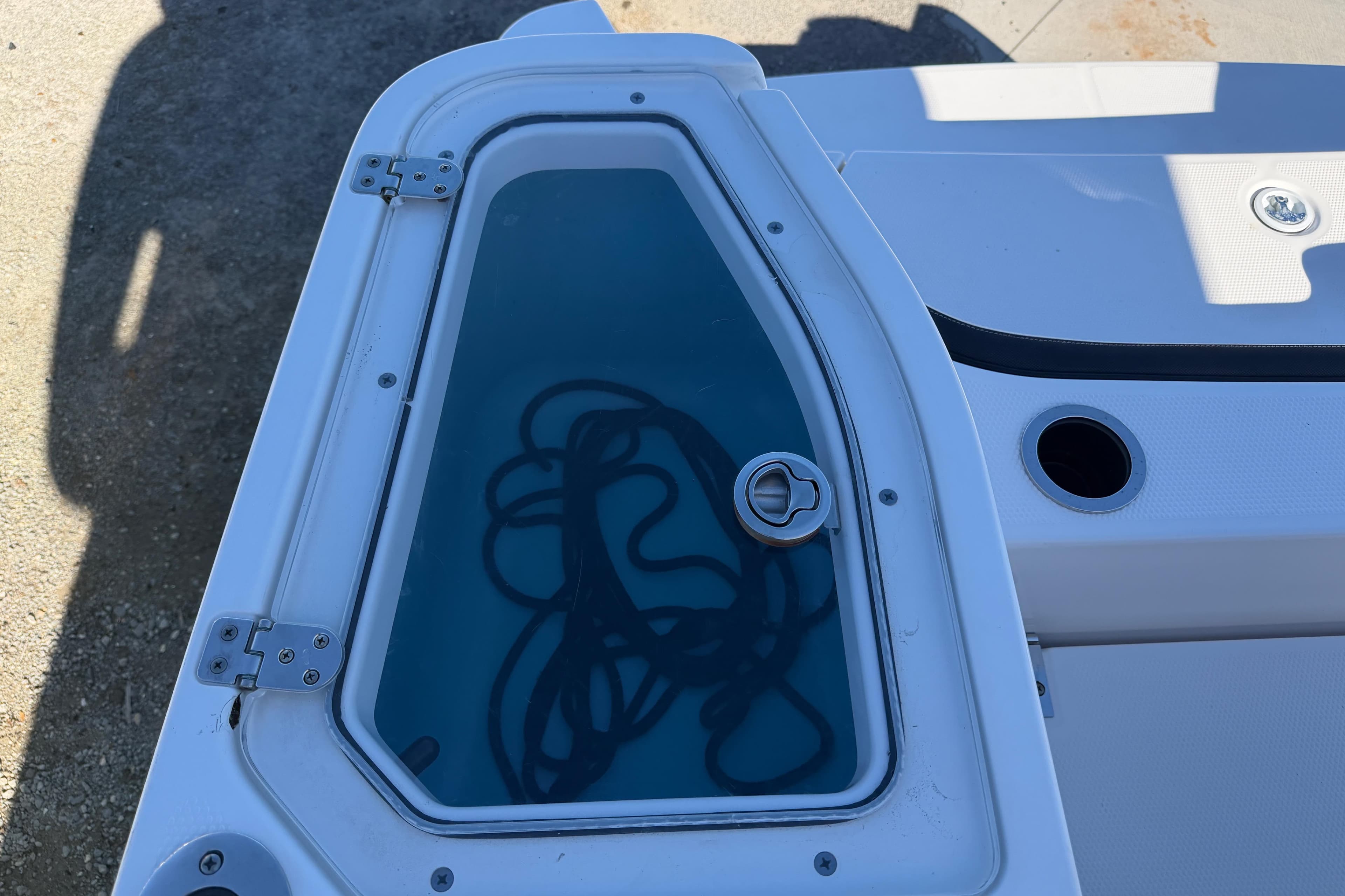 2022 Yamaha Boats 252 FSH Sport storage compartment with visible rope inside.