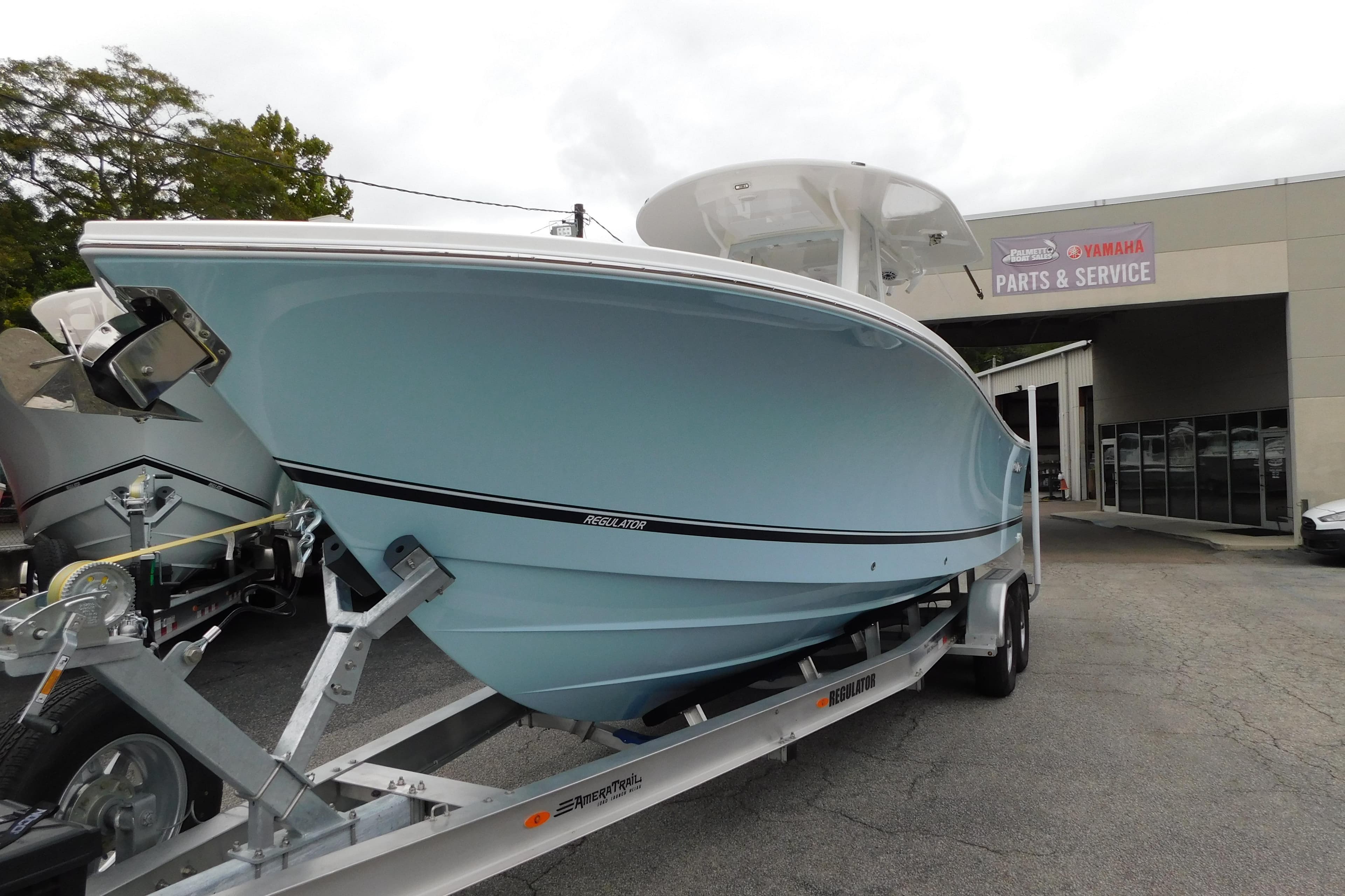 2026 Regulator 28 boat on trailer outside Yamaha parts and service center.