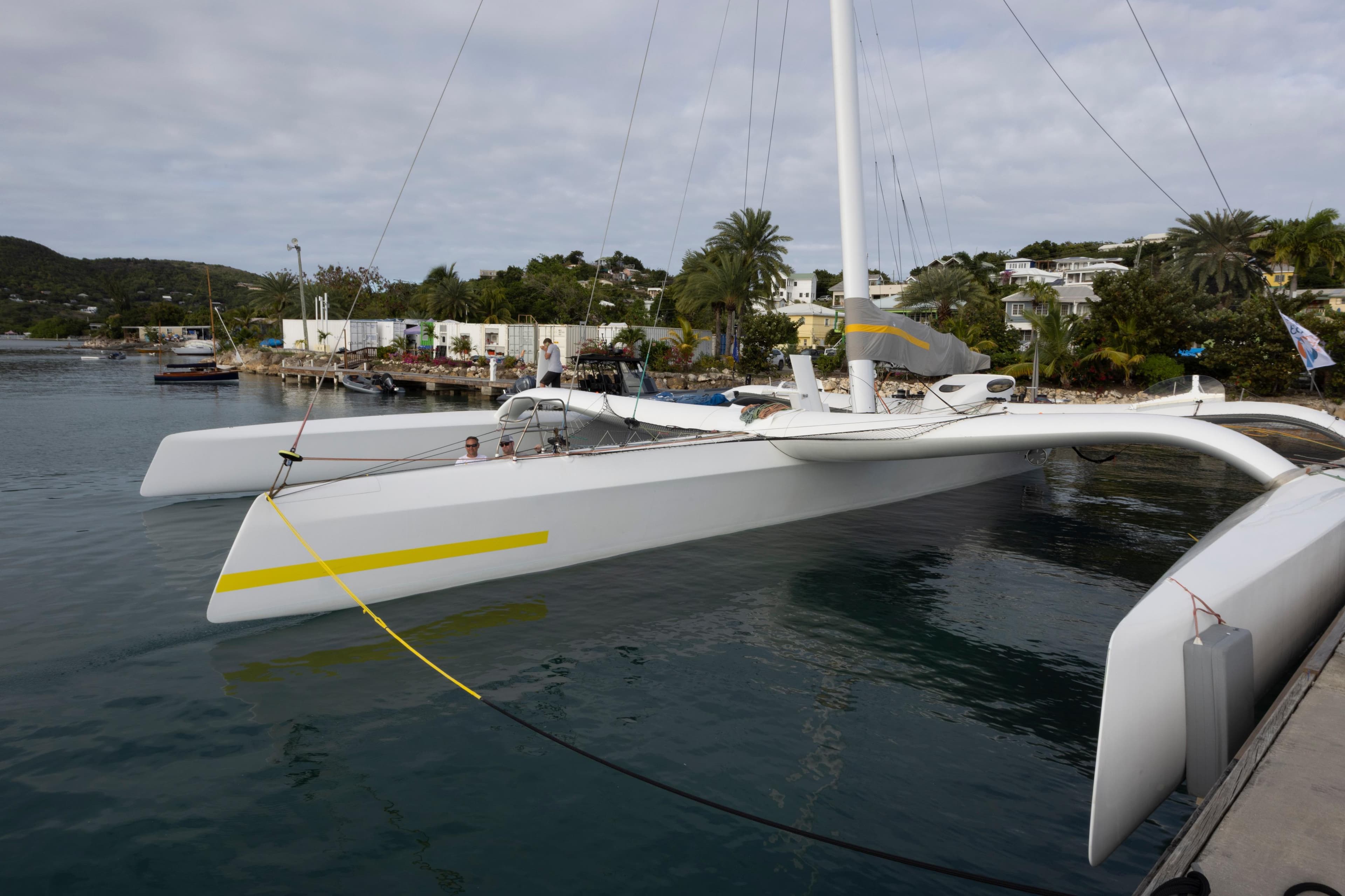 2012 CDK Technologies MOD 70 trimaran docked in a scenic harbor.