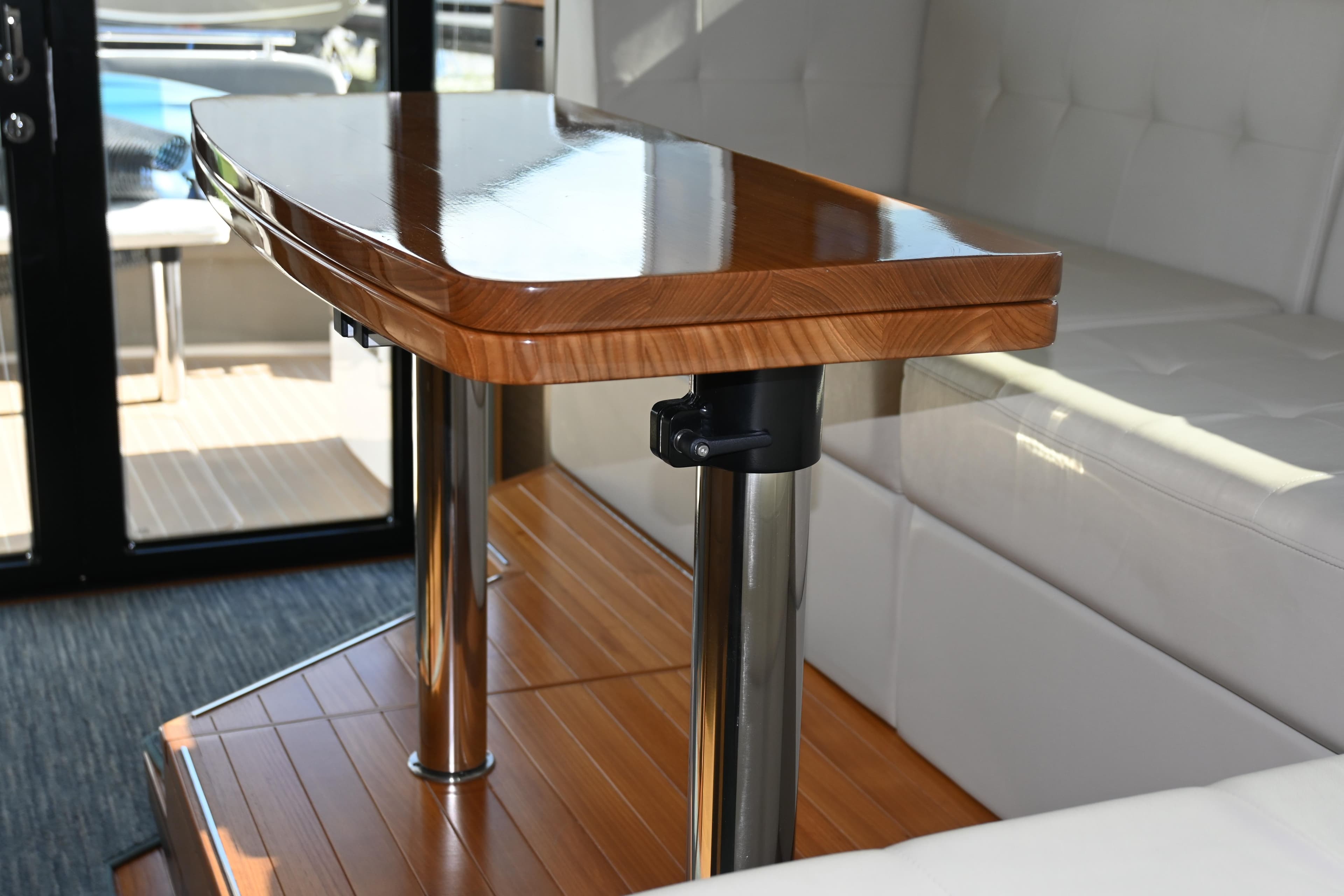 Luxurious interior of 2017 Tiara 44 Coupe with polished wooden table and plush seating.