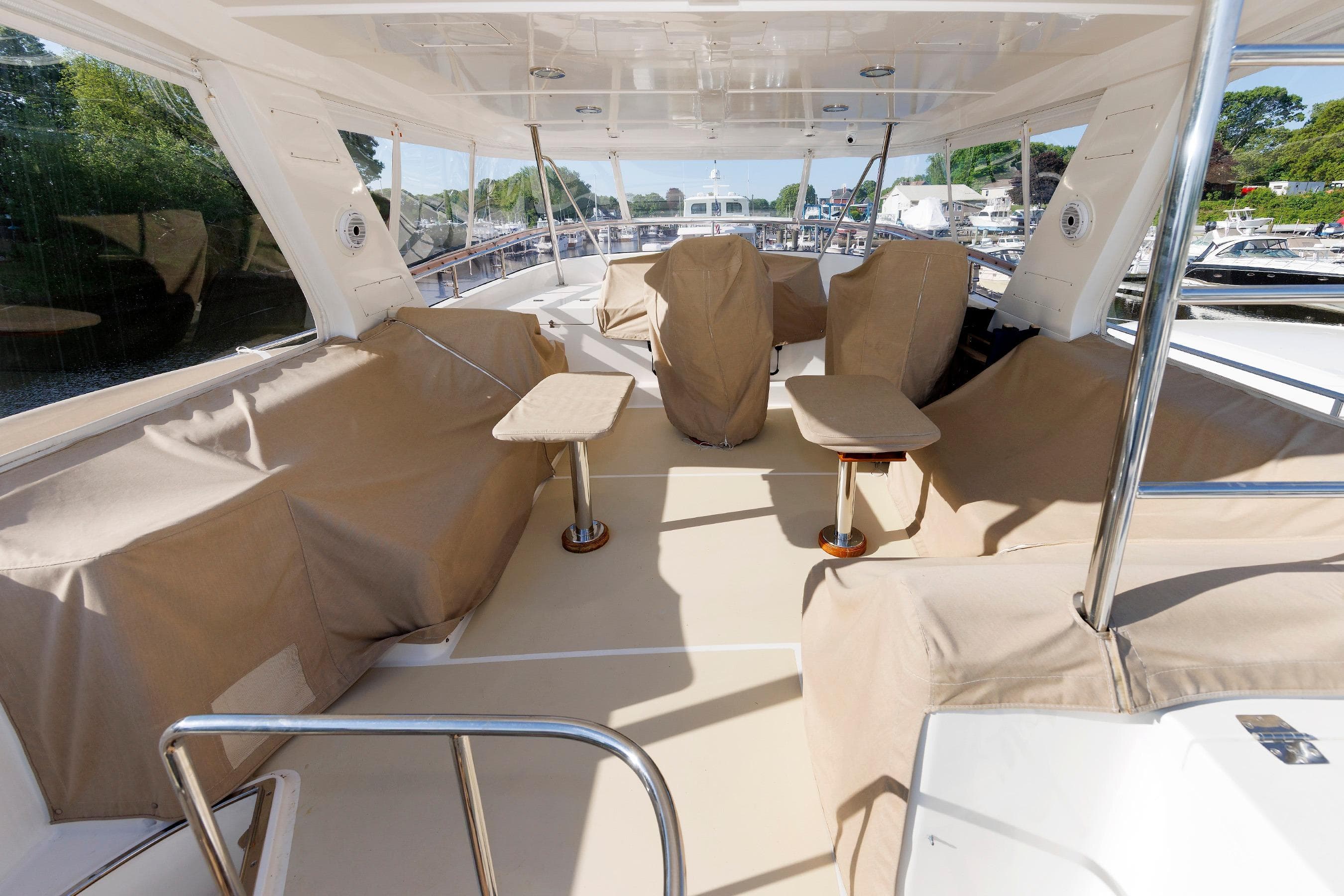Luxurious 2007 Grand Banks 59 Aleutian RP yacht deck with covered seating and tables.