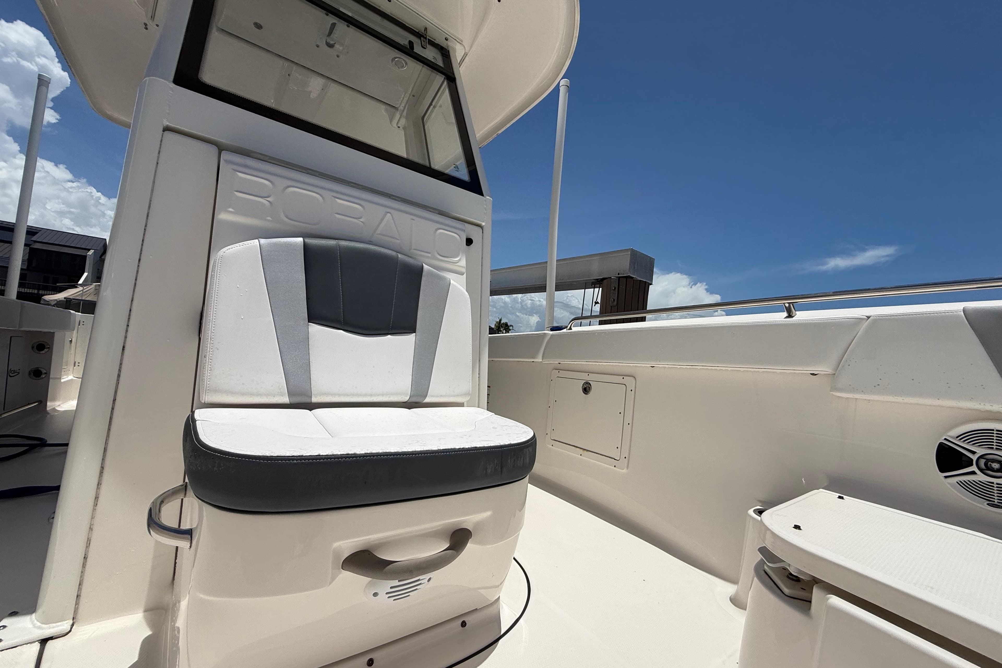 2020 Robalo R272 Center Console boat interior with cushioned seating under clear blue sky.