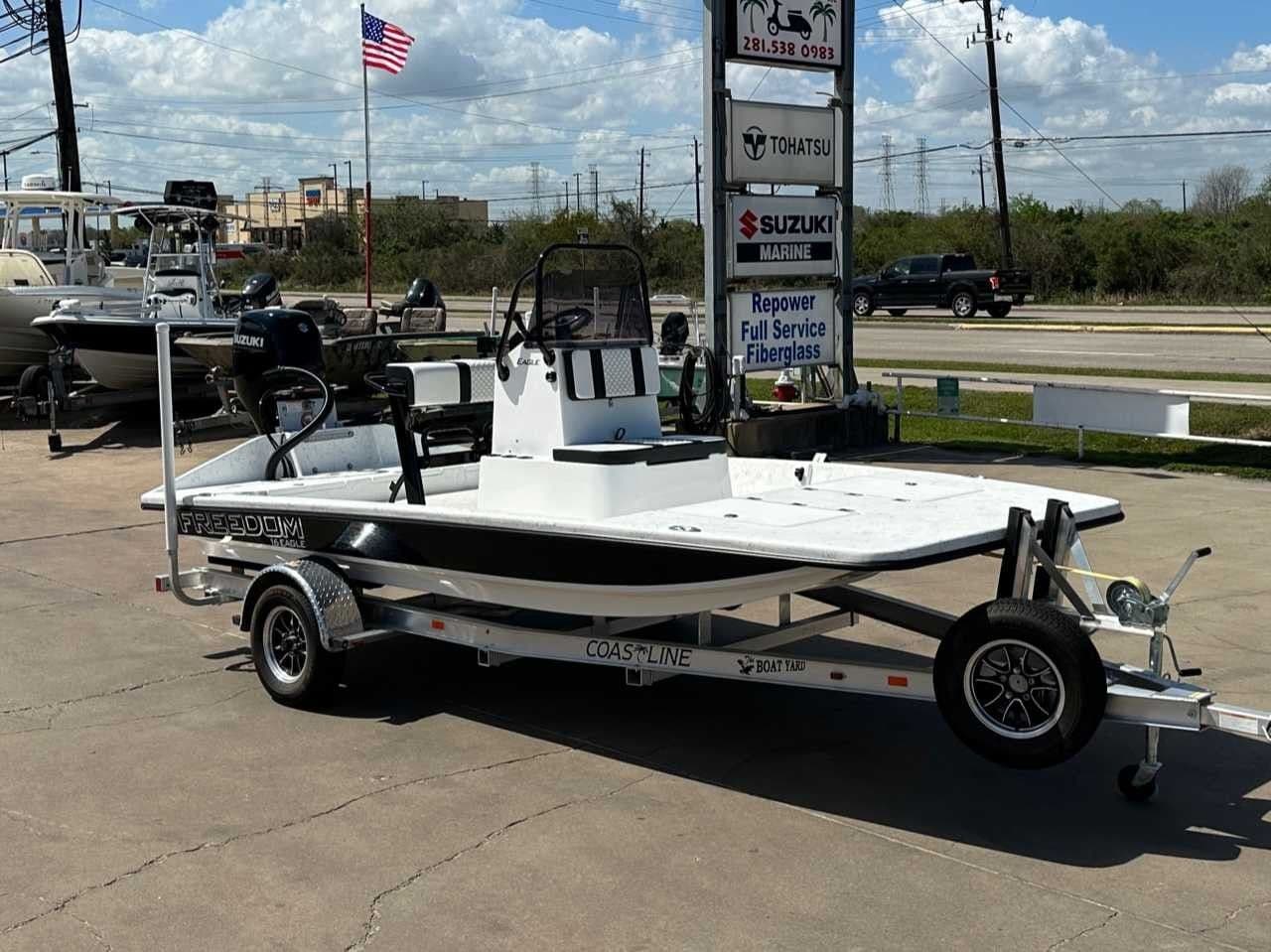 2026 Freedom Boats EAGLE on trailer, Suzuki engine, American flag in background.