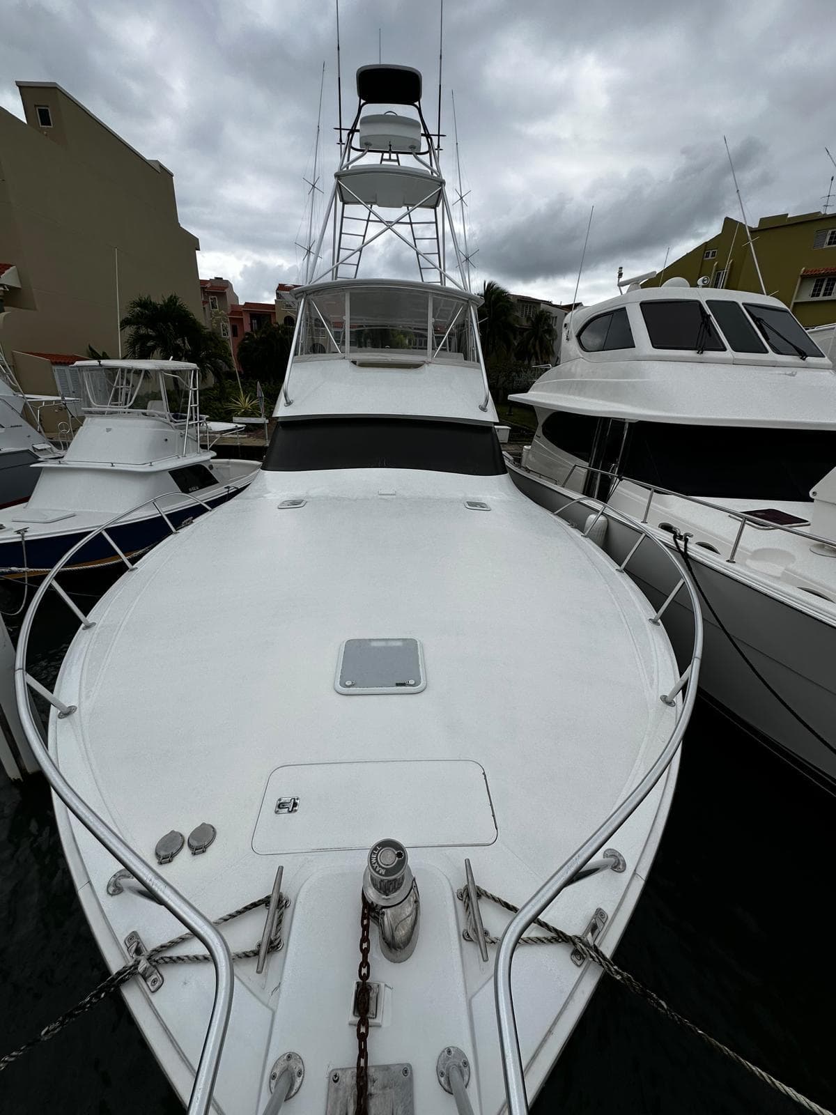 2003 Viking 52 yacht docked, front view, overcast sky, surrounded by other boats.