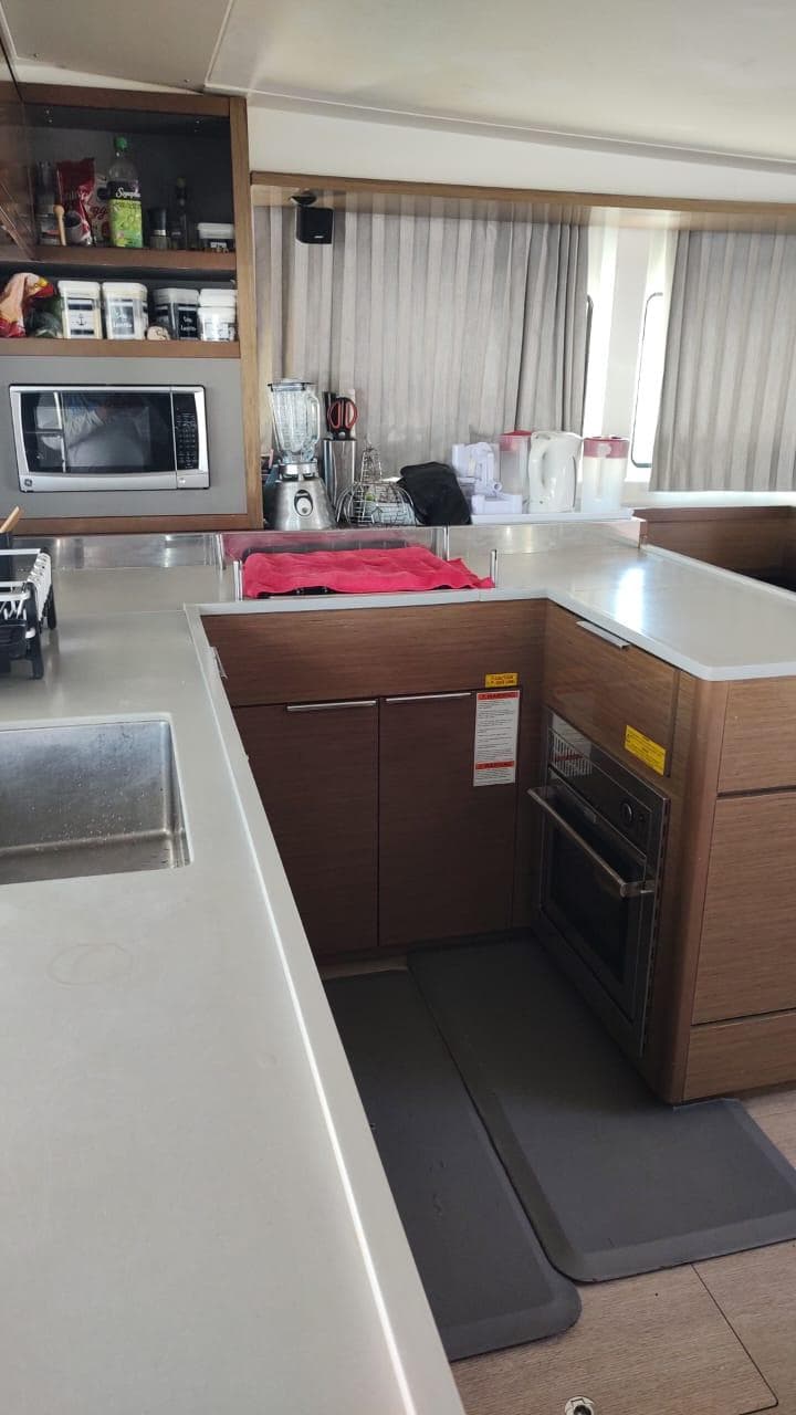 Modern kitchen interior of 2020 Lagoon 46 catamaran with appliances and sleek countertops.