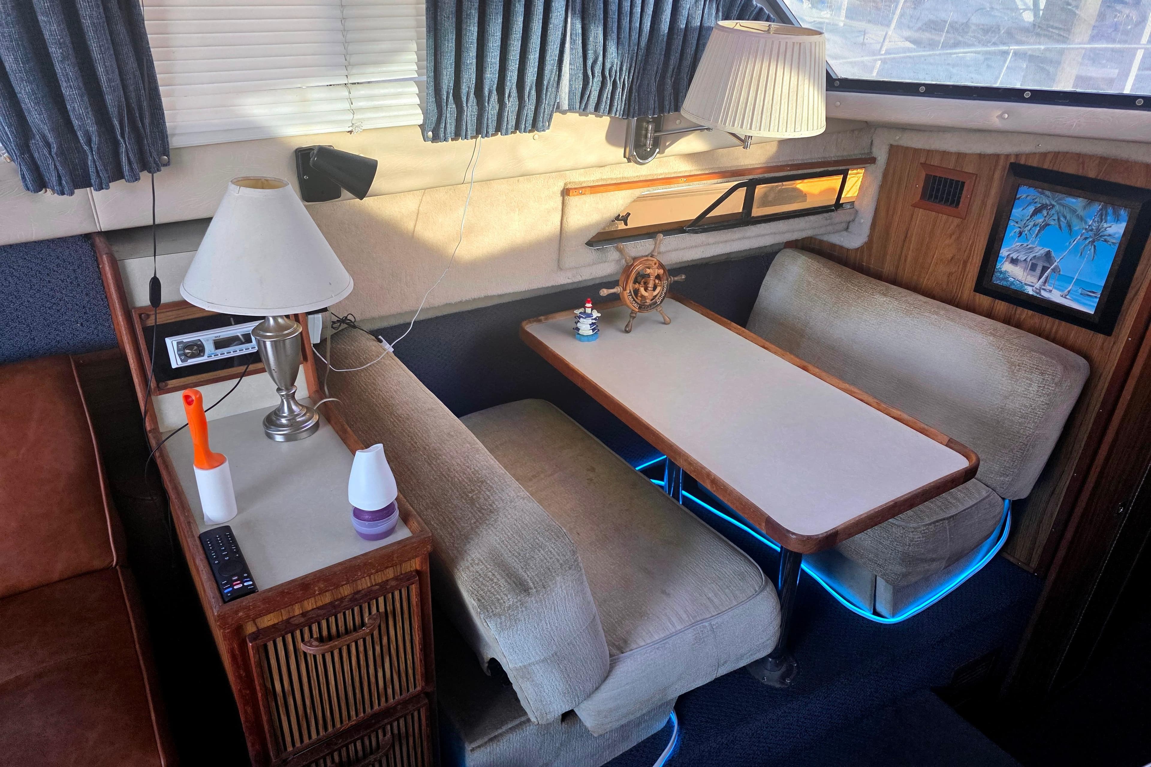 Interior of 1985 Sea Ray 340 Sedan Bridge with cozy dining area and nautical decor.