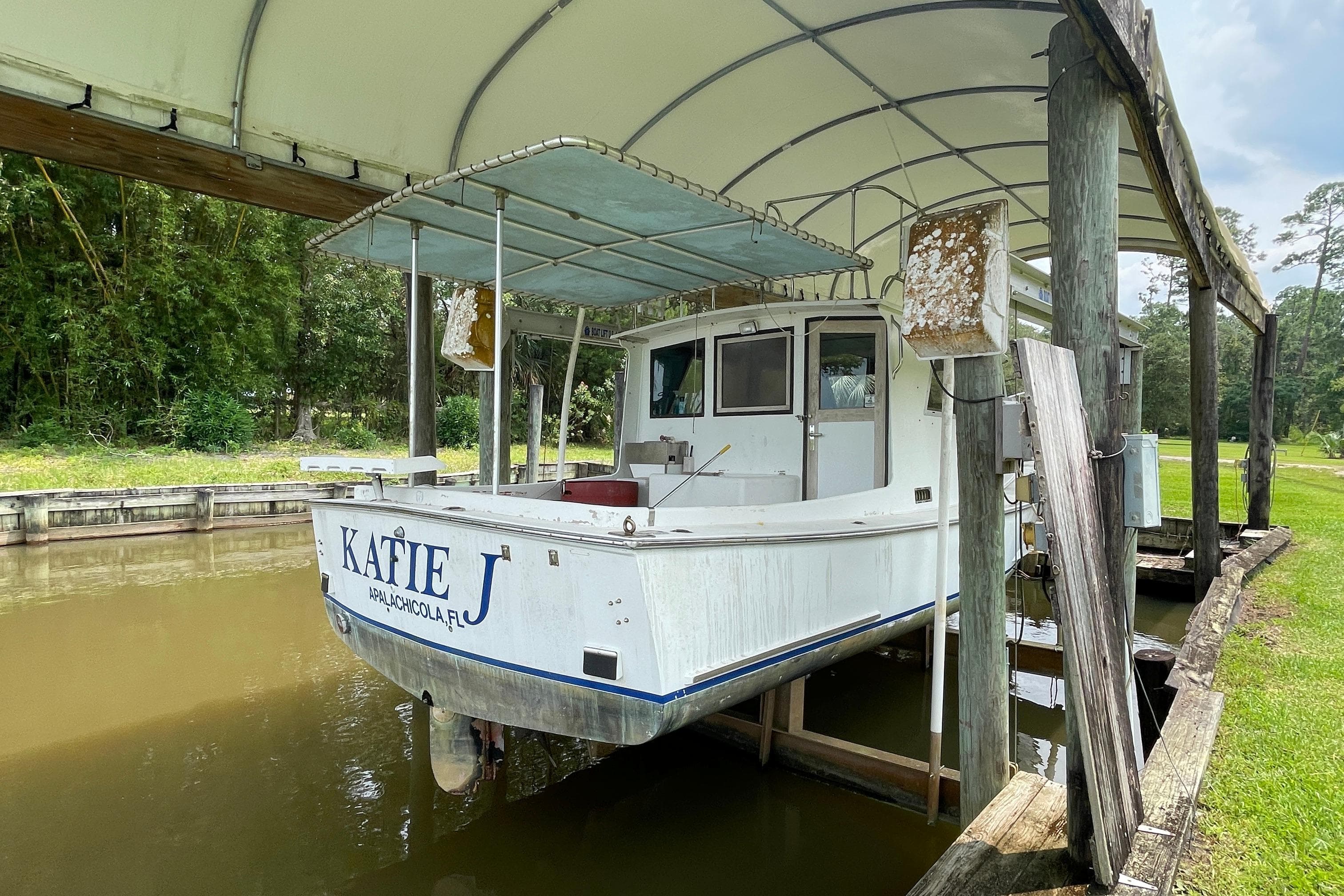 1995 Stuart Angler 33 Downeast boat Katie J docked under a canopy.