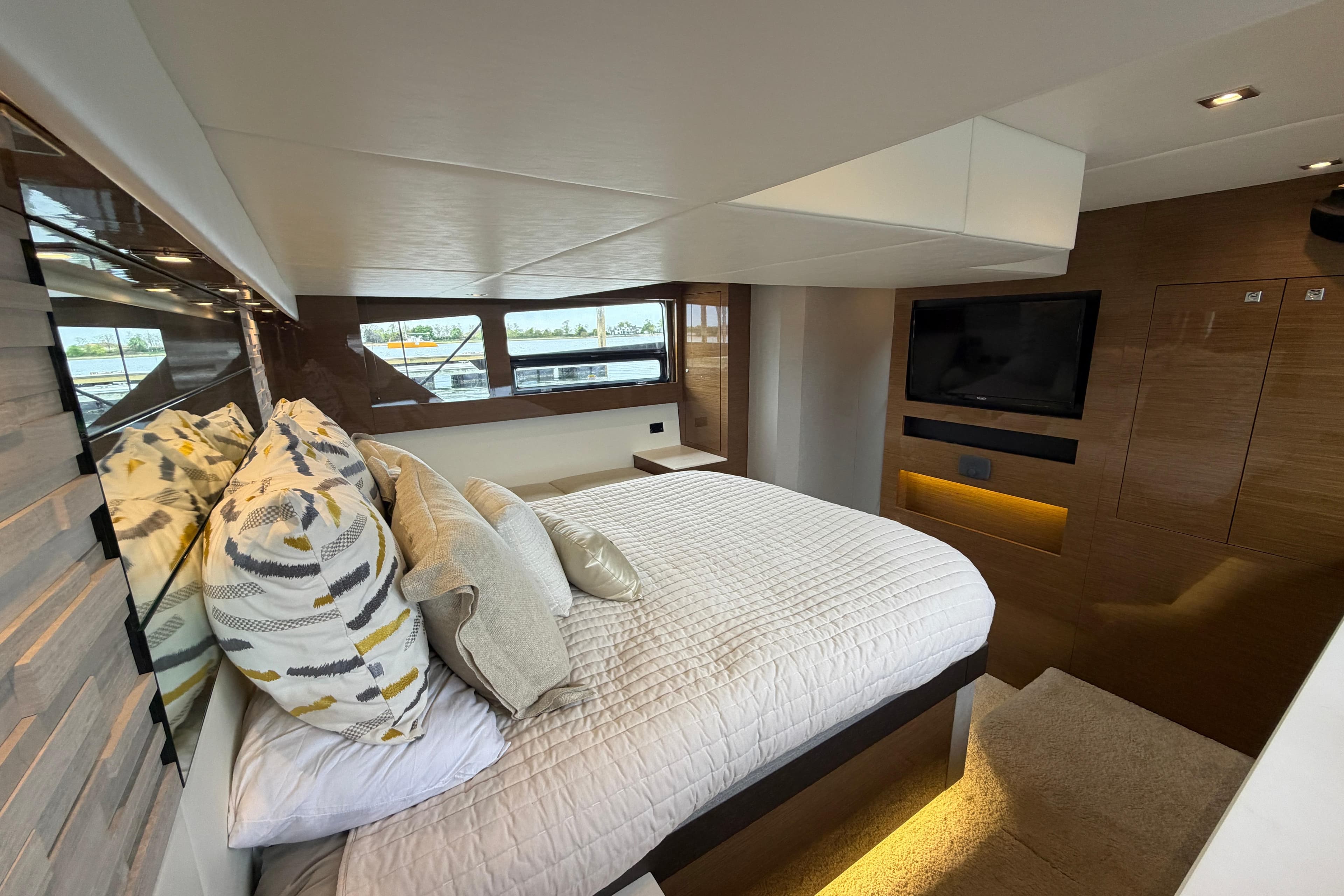 Luxurious bedroom interior of 2018 Cruisers Yachts 50 Cantius with modern design and large windows.