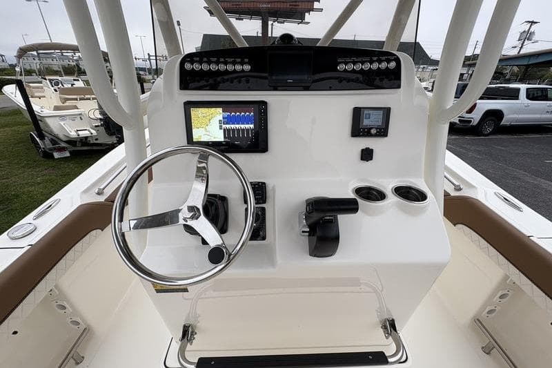 2026 Pioneer 222 Sportfish boat dashboard with steering wheel, navigation screen, and controls.