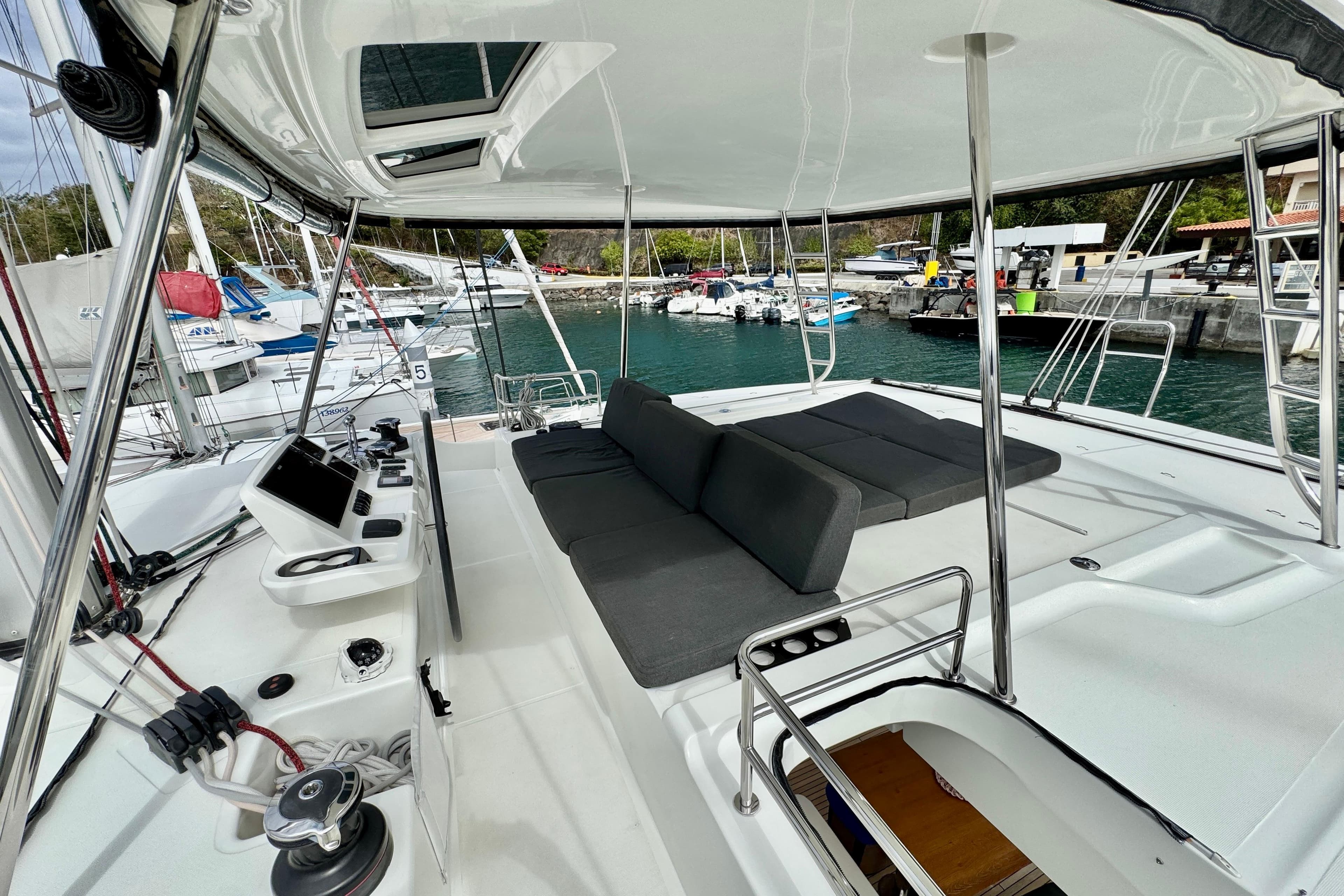 Luxurious 2021 Lagoon 50 catamaran deck with seating, docked at a marina.