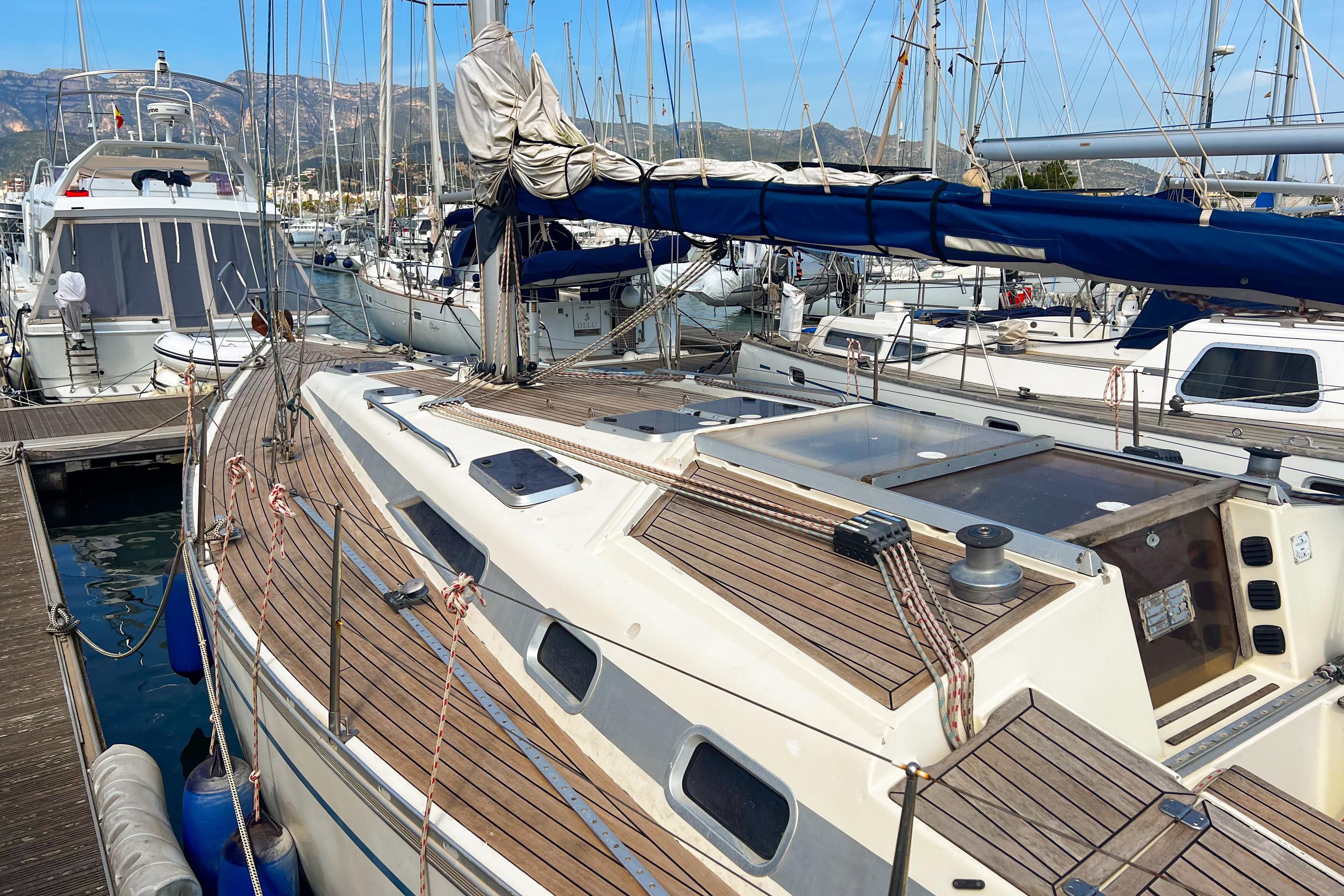 Sailboat Bavaria 42 Caribic 1988 docked in a marina with other boats.