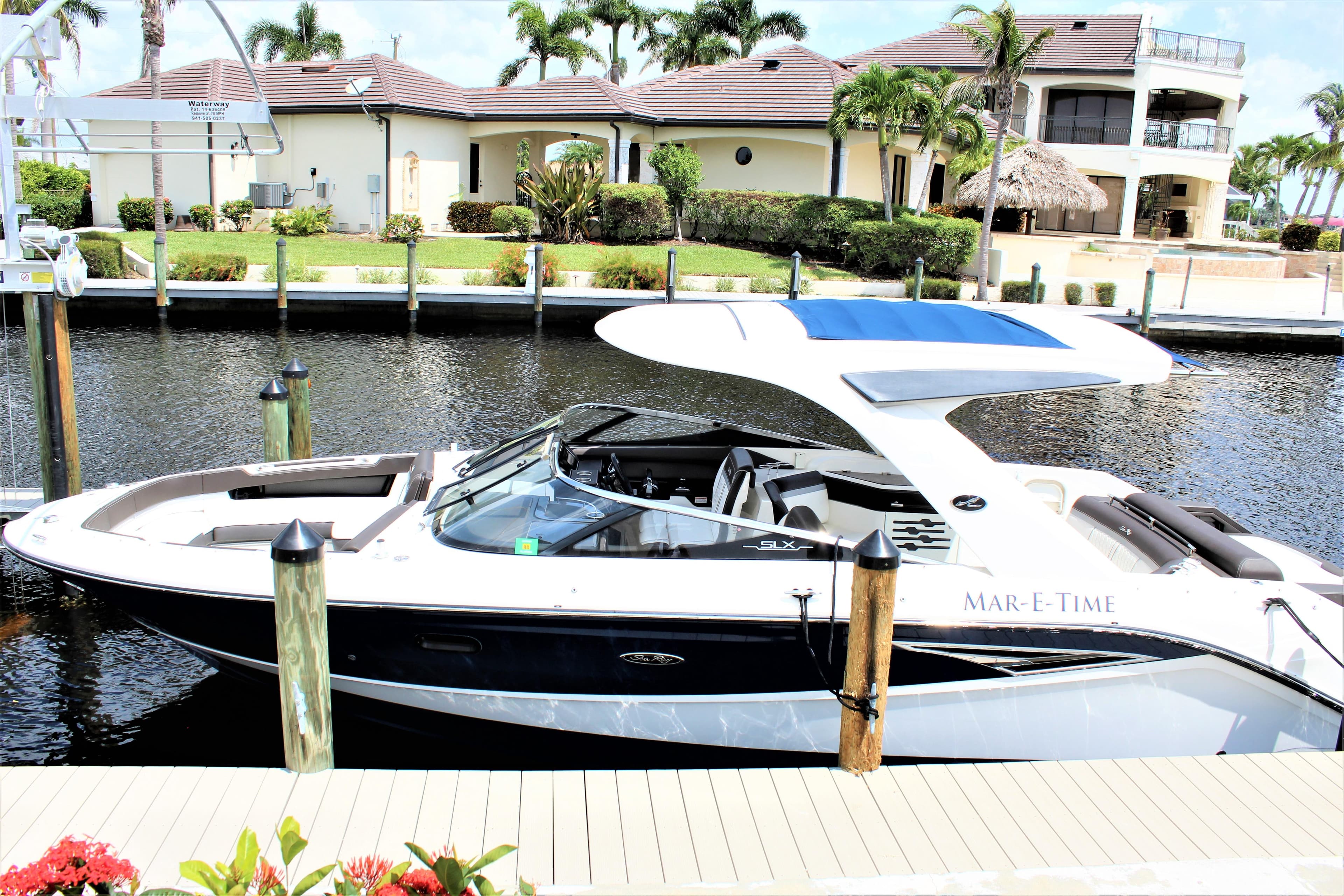 2017 Sea Ray SLX 310 boat docked in front of villa.