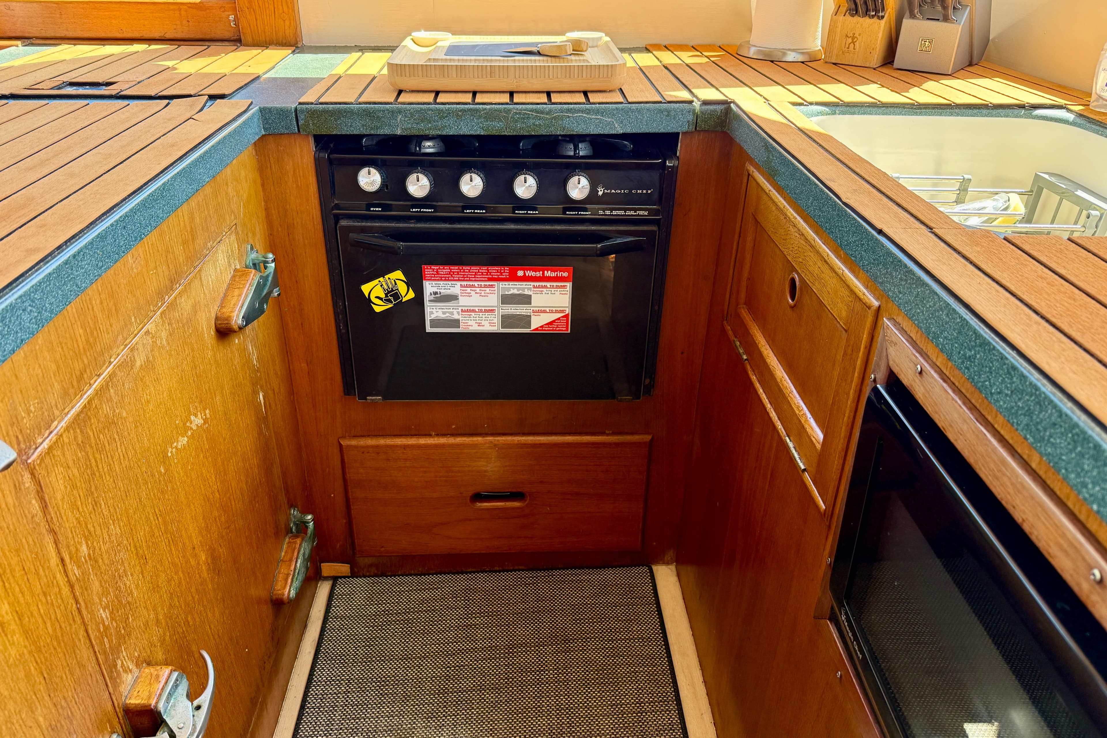 1991 Kong & Halvorsen Island Gypsy yacht kitchen with wooden cabinetry and stove.