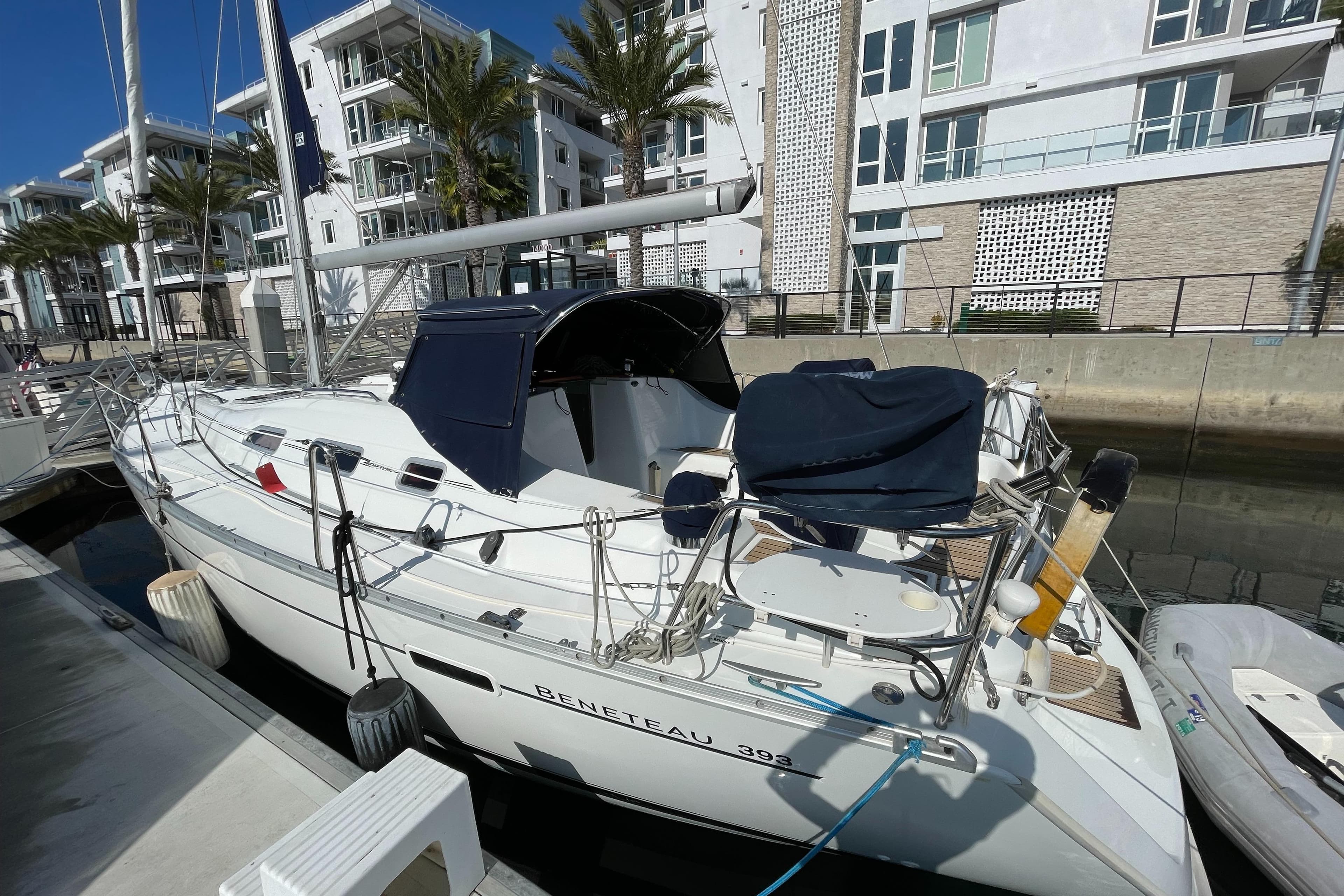 2006 Beneteau 393 sailboat docked near modern waterfront buildings.
