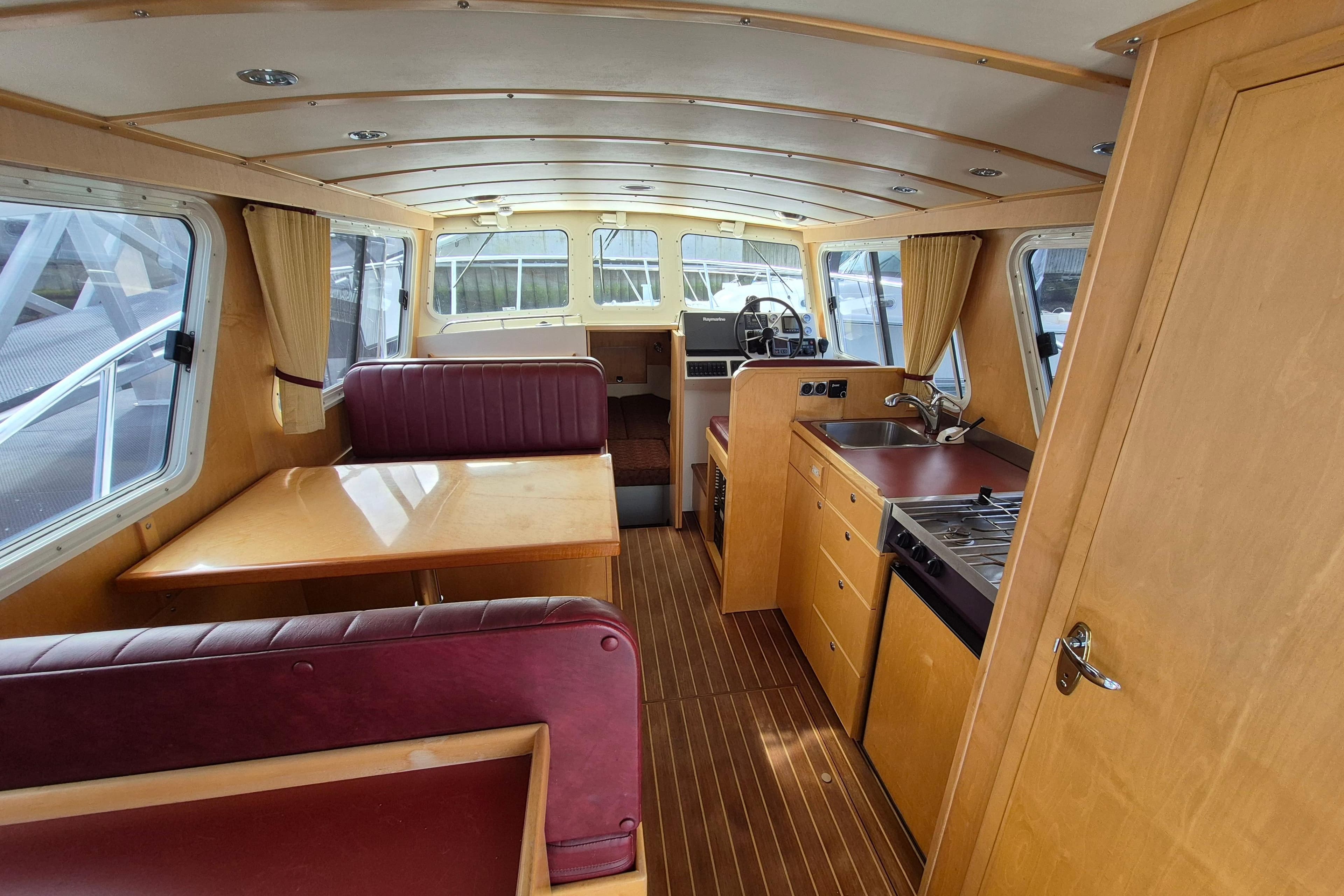 Interior of 2004 Coastal Craft 300 Cruiser with dining area and kitchenette.