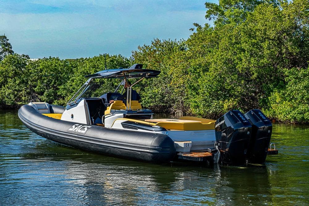 2025 SACS Strider 11 boat with dual engines on a serene waterway.