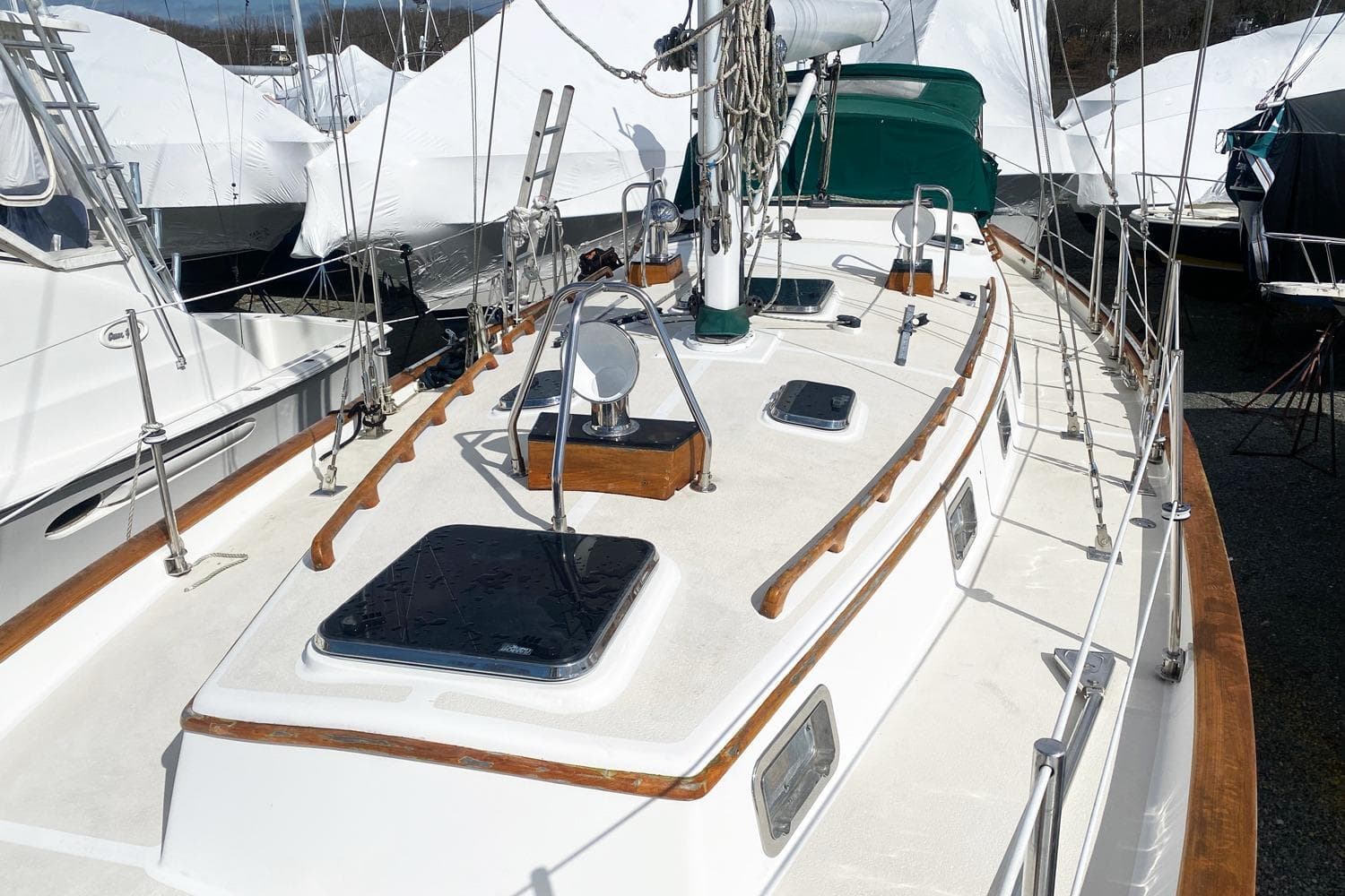 2005 Cabo Rico 42 Cutter sailboat deck with wooden trim and hatches.