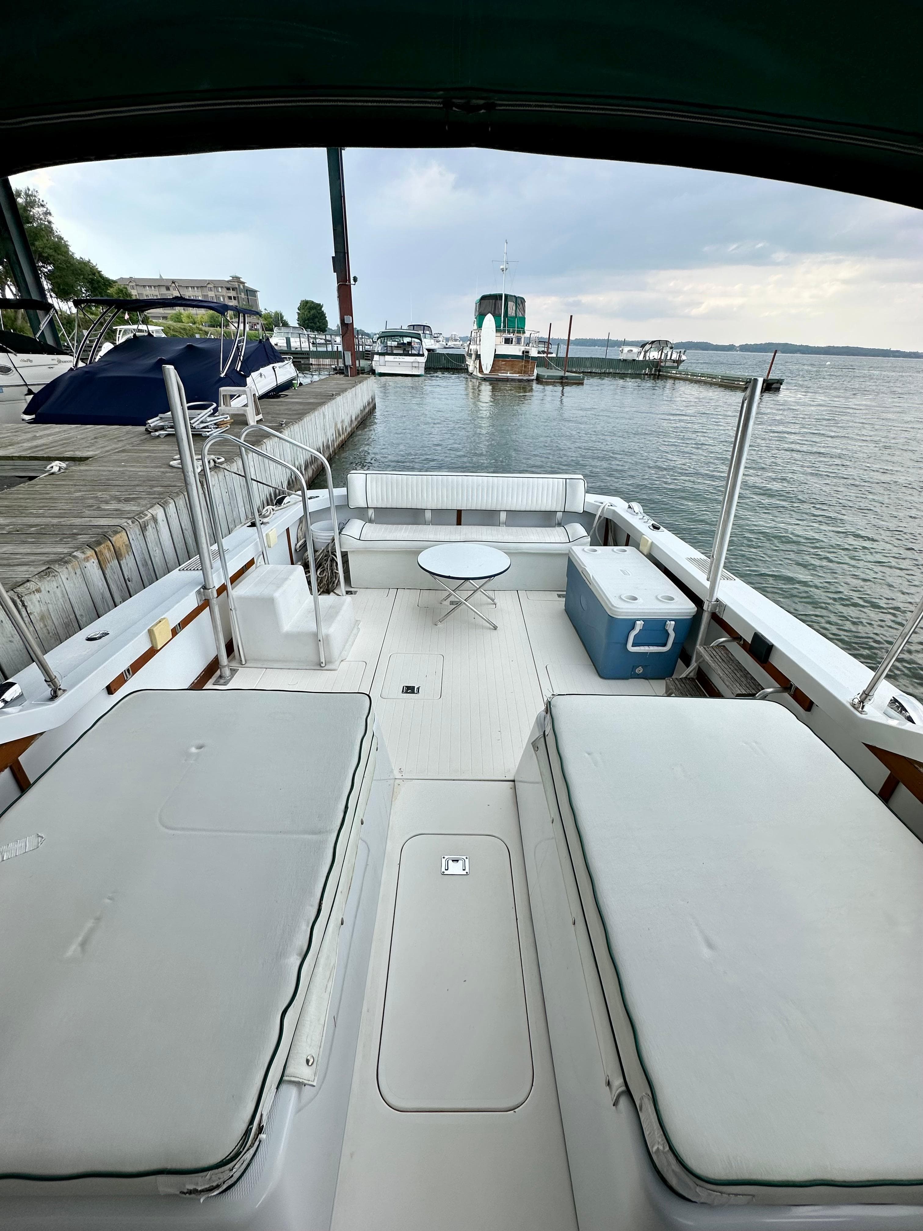 1966 Bertram 31 Bahia Mar boat interior with seating and table, docked by the water.