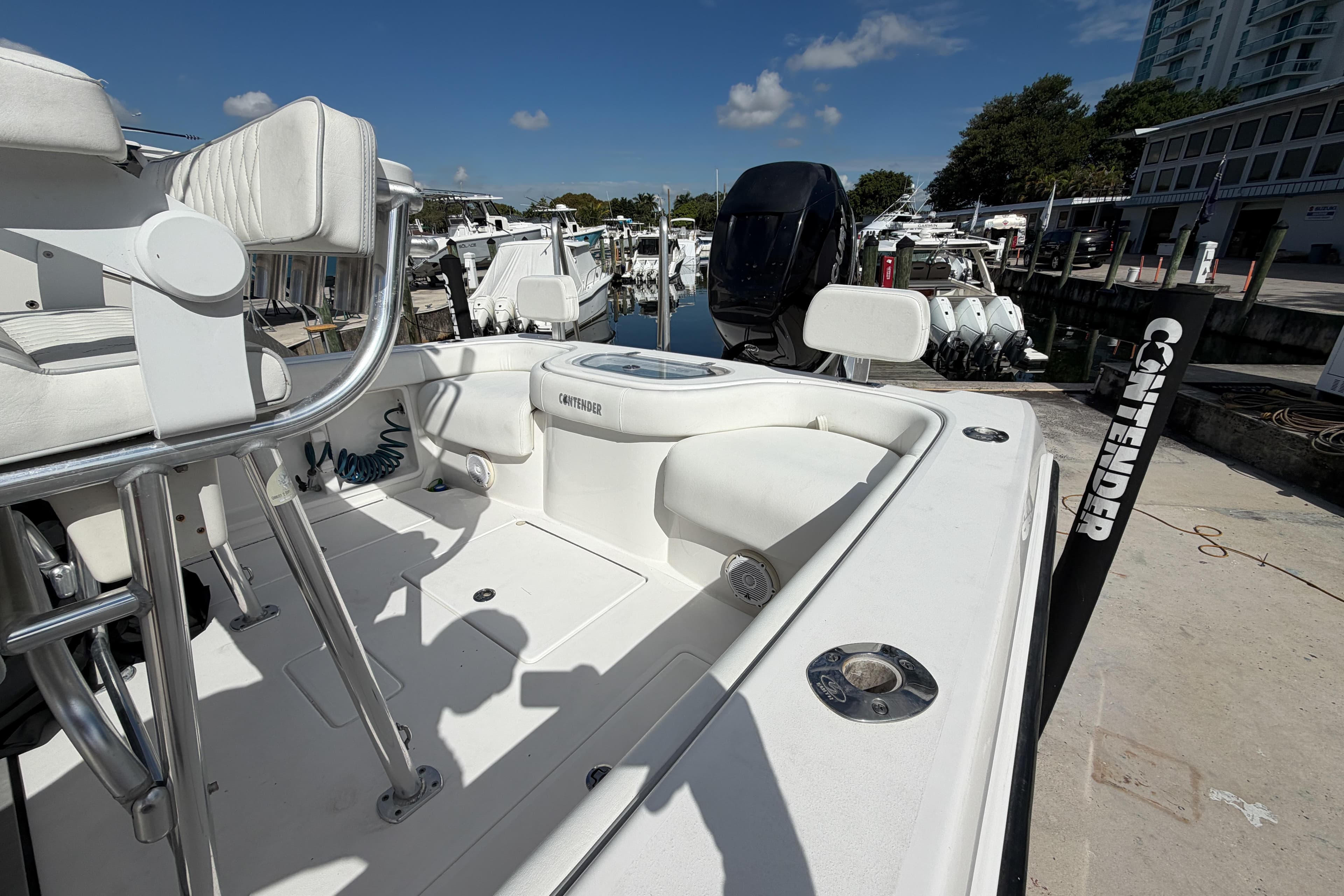 2016 Contender 24 Sport boat docked, featuring white seating and modern design.