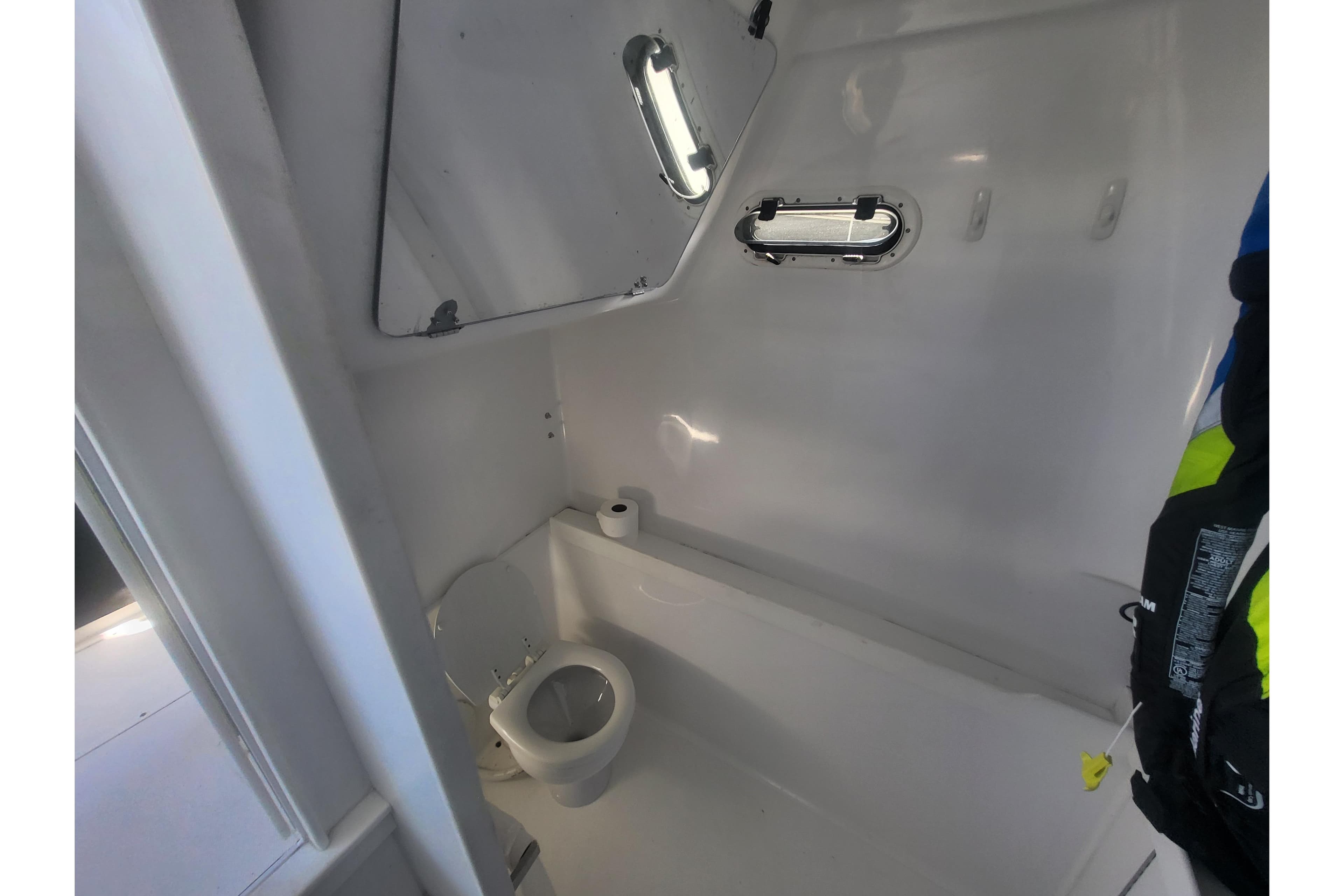 2005 Stamas 310 Tarpon boat interior bathroom with toilet and porthole window.