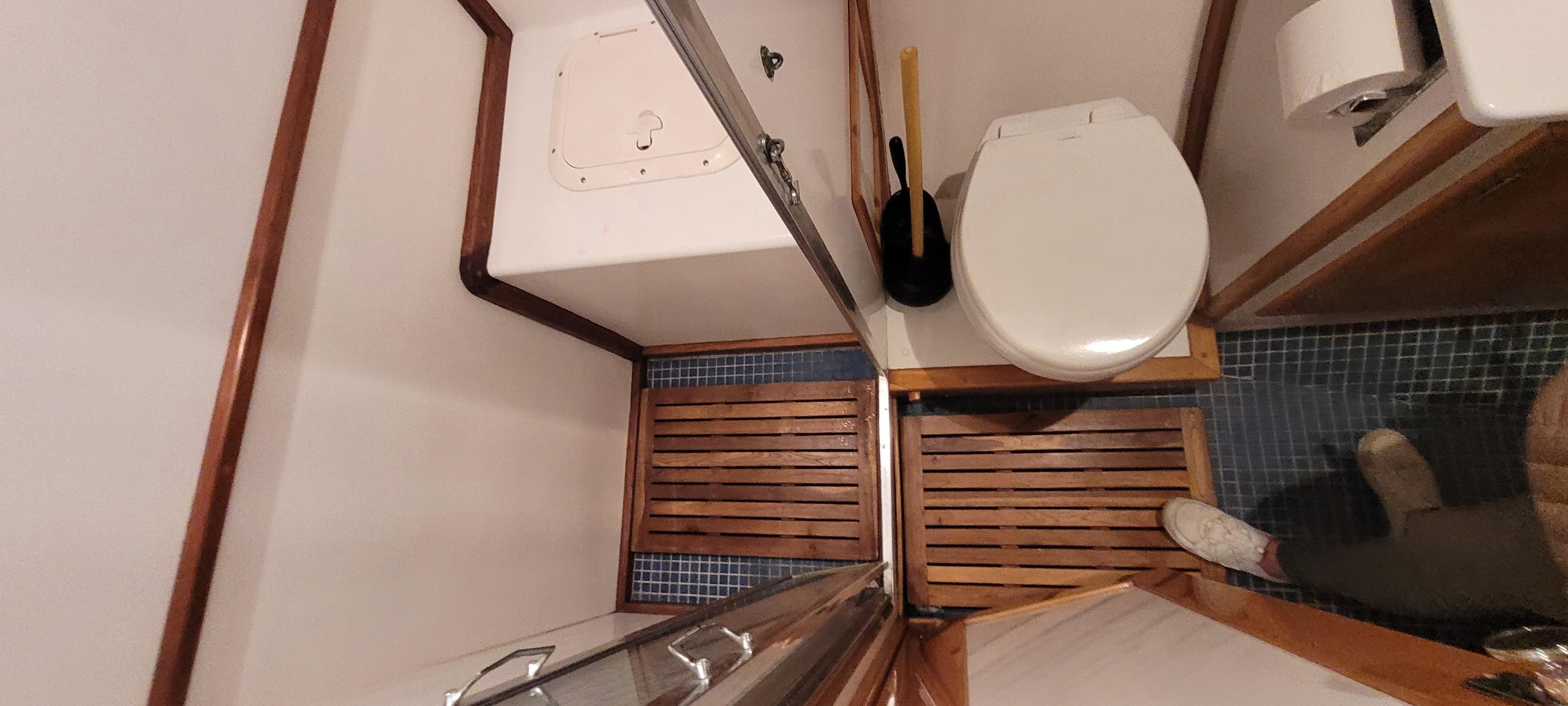 Bathroom interior of 1989 Duffy Wilbur 42 Flybridge Cruiser with wooden flooring and toilet.