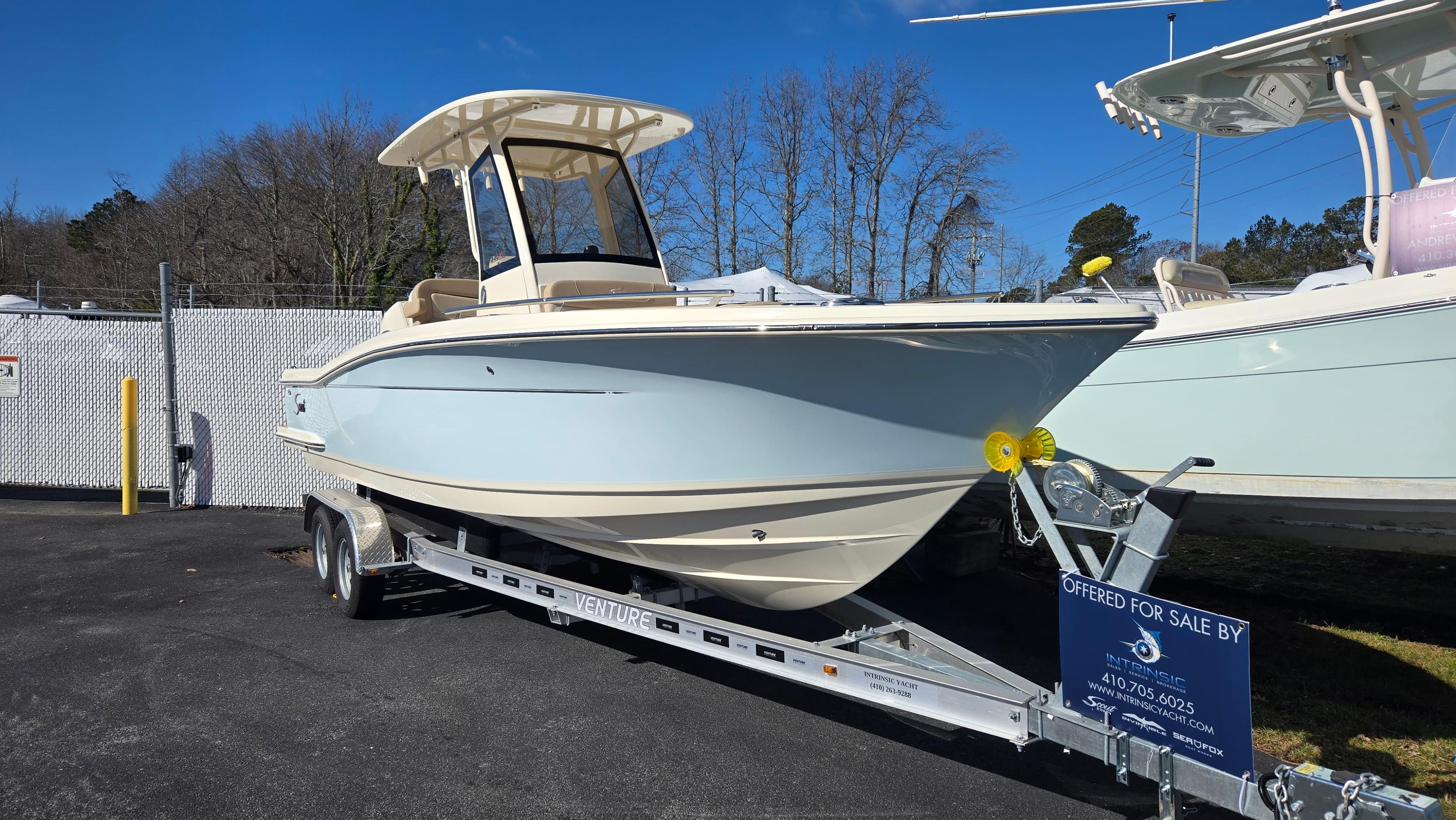 2024 Scout 240 XSF boat on trailer, displayed outdoors under clear blue sky.