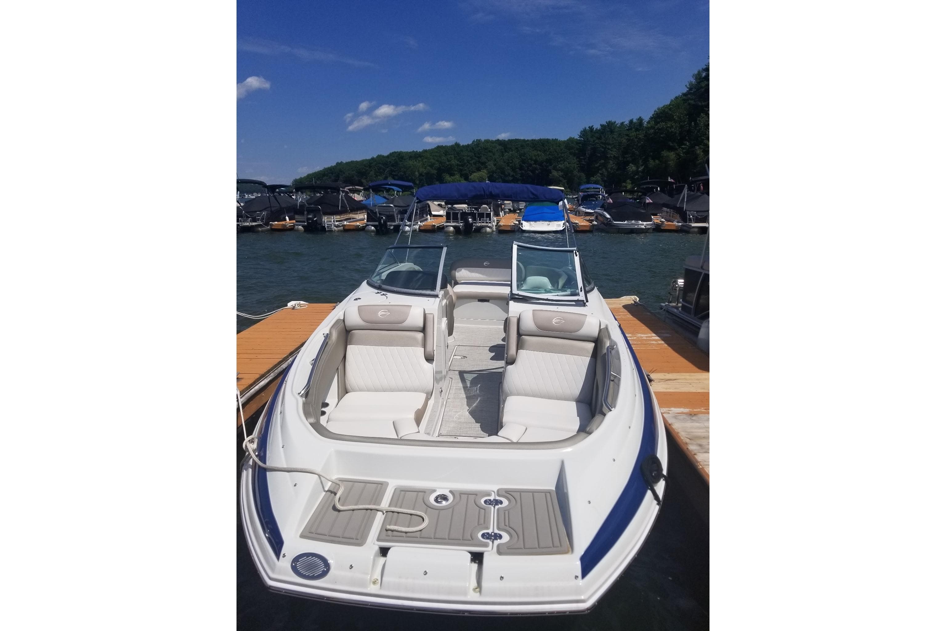 2022 Crownline Eclipse E255 boat docked at a marina under a clear blue sky.