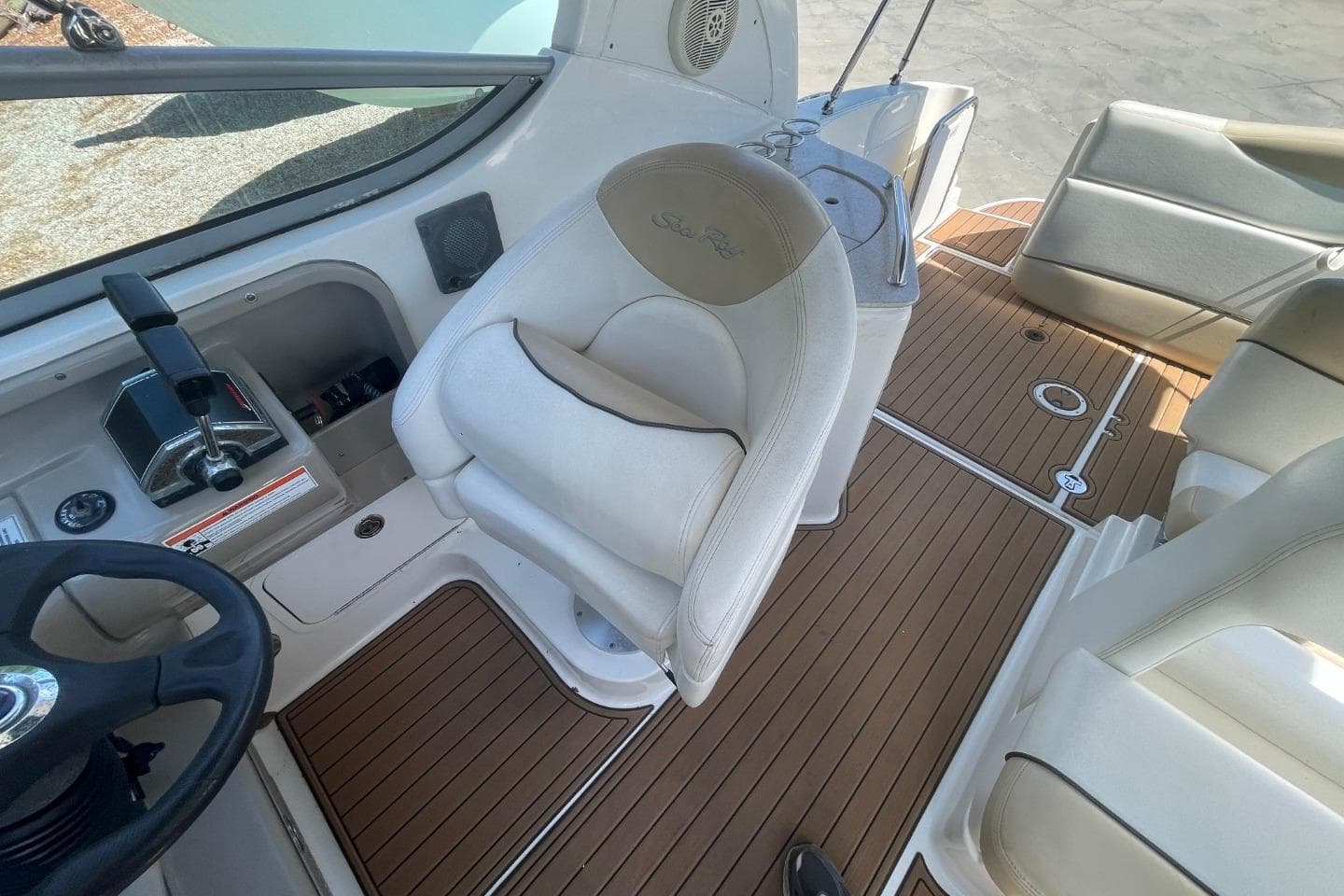 2008 Sea Ray Sundancer 280 cockpit with beige seating and wood-style flooring.