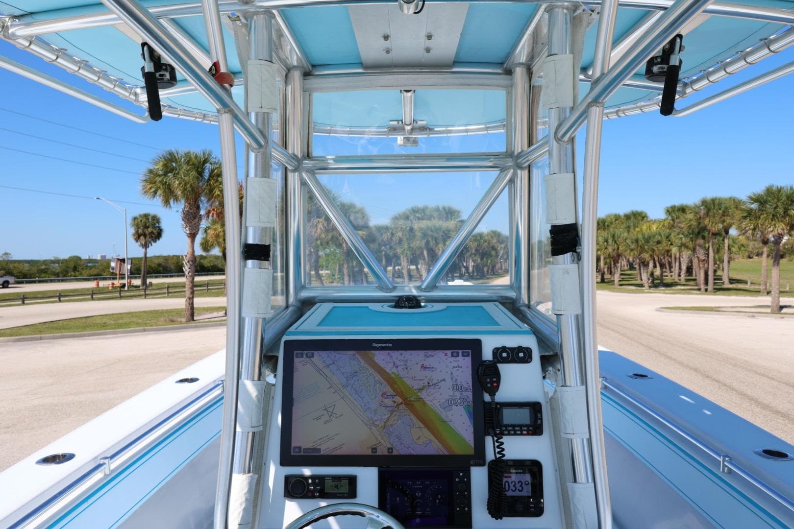 2003 Contender 36 Open boat cockpit with navigation system, palm trees in background.