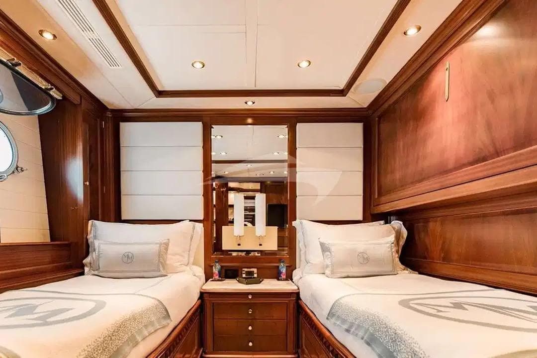 Luxurious twin cabin interior on 2007 Benetti 120 Classic yacht, featuring elegant wood paneling.