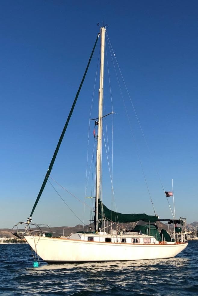 1978 Bristol 40 sailboat on calm water under clear blue sky.