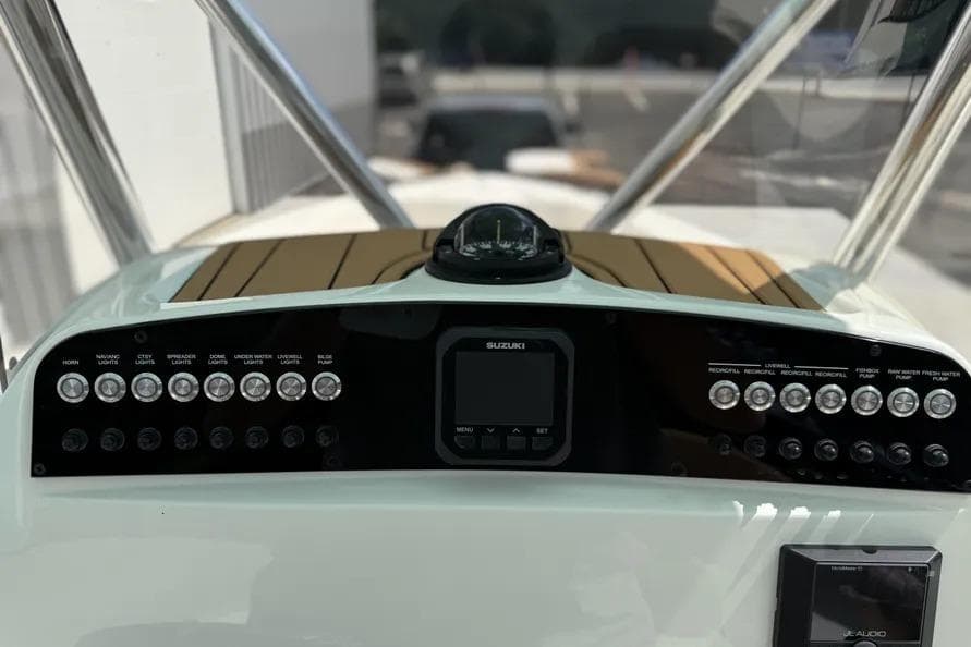 2026 Pioneer 220 Bay Sport boat dashboard with Suzuki controls and various switches.
