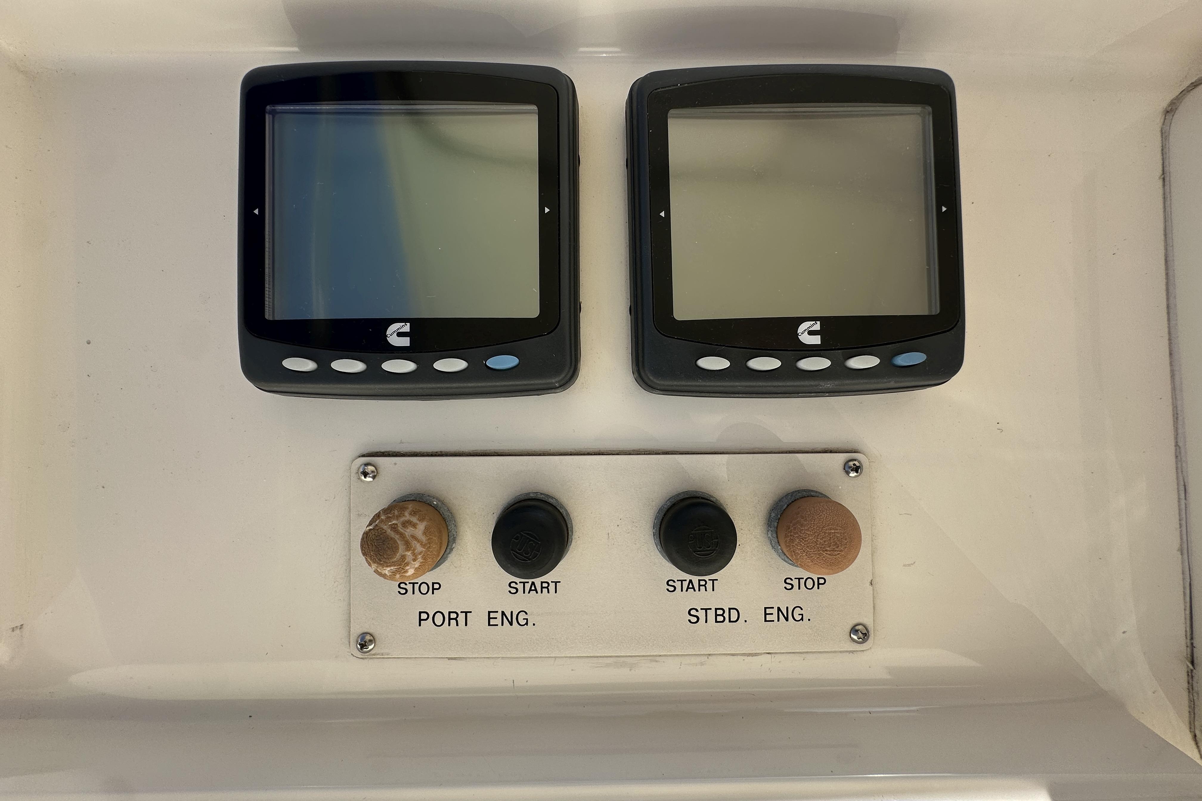 Control panel of a 2004 McKinna 57 PHMY Widebody yacht with dual screens and engine buttons.